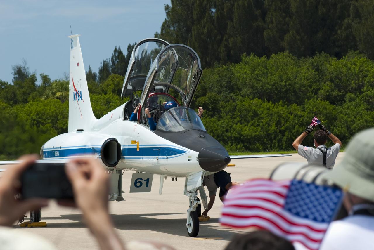 CAPE CANAVERAL, Fla. -- On the Shuttle Landing Facility (SLF) at NASA's Kennedy Space Center in Florida, Kennedy SLF crews signal STS-135 Commander Chris Ferguson and Mission Specialist Sandy Magnus to stop on the tarmac. The STS-135 astronauts arrived at Kennedy about 2:30 p.m. EDT on July 4 for final preparations for space shuttle Atlantis' STS-135 mission to the International Space Station. Atlantis is scheduled to lift off on July 8 to deliver the Raffaello multi-purpose logistics module packed with supplies and spare parts to the station. The STS-135 mission also will fly a system to investigate the potential for robotically refueling existing satellites and return a failed ammonia pump module to help NASA better understand the failure mechanism and improve pump designs for future systems. STS-135 will be the 33rd flight of Atlantis, the 37th shuttle mission to the space station, and the 135th and final mission of NASA's Space Shuttle Program. For more information visit, www.nasa.gov/mission_pages/shuttle/shuttlemissions/sts135/index.html. Photo credit: NASA/Jim Grossmann