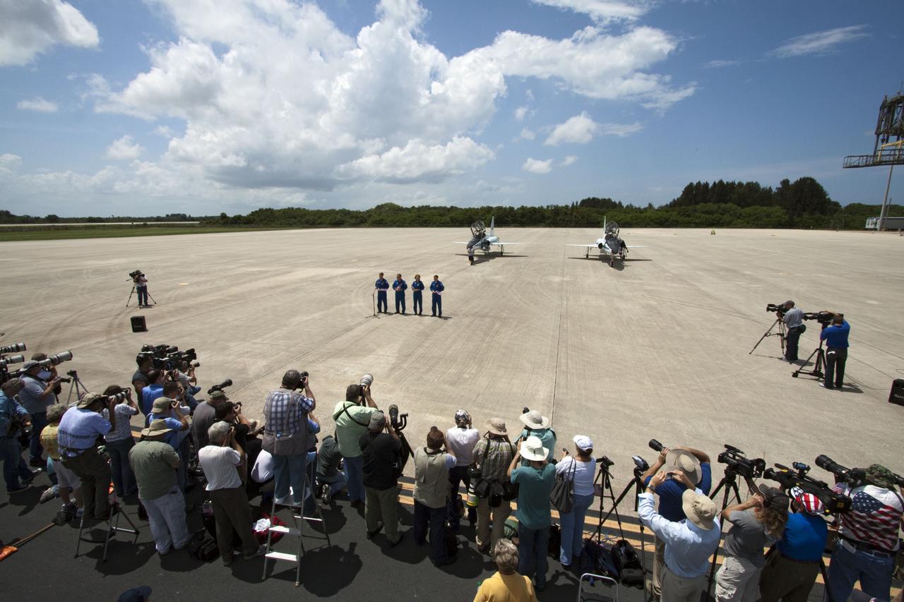 CAPE CANAVERAL, Fla. -- The STS-135 crew members speak to media after their arrival at NASA Kennedy Space Center's Shuttle Landing Facility in Florida. From left are Commander Chris Ferguson, Pilot Doug Hurley and Mission Specialists Sandy Magnus and Rex Walheim. The STS-135 astronauts arrived at Kennedy about 2:30 p.m. EDT on July 4 for final preparations for space shuttle Atlantis' STS-135 mission to the International Space Station. Atlantis is scheduled to lift off on July 8 to deliver the Raffaello multi-purpose logistics module packed with supplies and spare parts to the station. The STS-135 mission also will fly a system to investigate the potential for robotically refueling existing satellites and return a failed ammonia pump module to help NASA better understand the failure mechanism and improve pump designs for future systems. STS-135 will be the 33rd flight of Atlantis, the 37th shuttle mission to the space station, and the 135th and final mission of NASA's Space Shuttle Program. For more information visit, www.nasa.gov/mission_pages/shuttle/shuttlemissions/sts135/index.html. Photo credit: NASA/Ken Thornsley