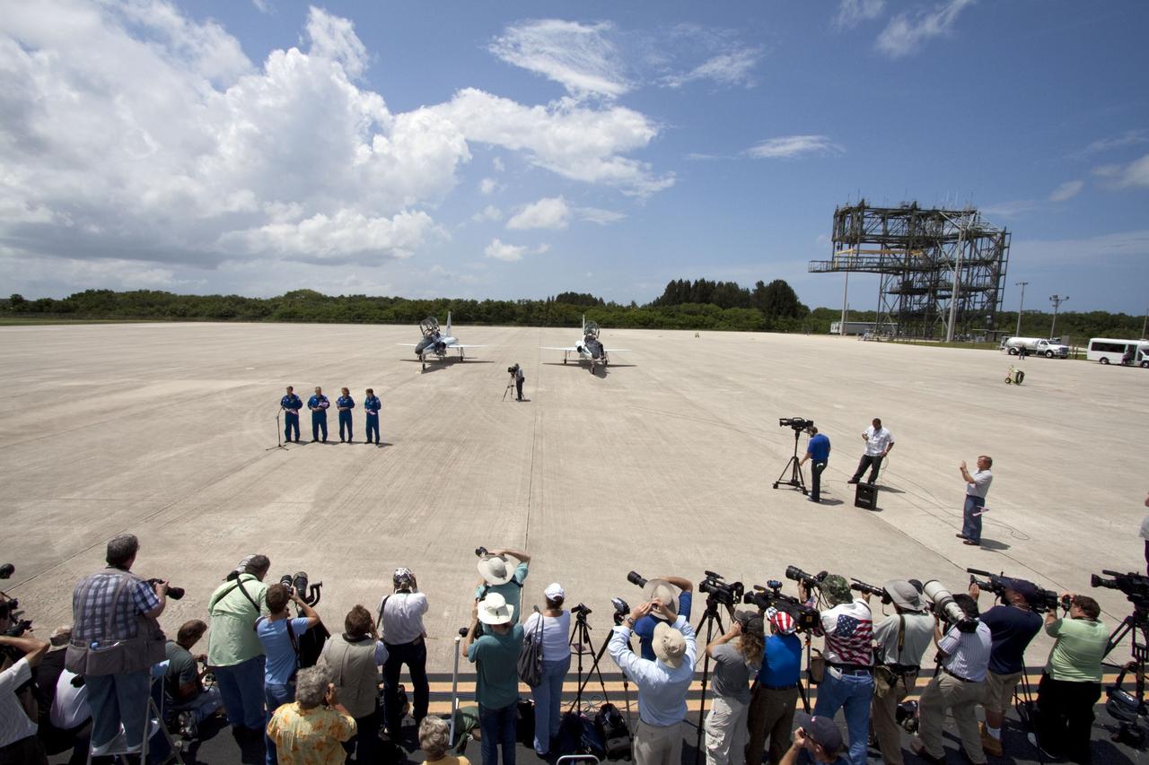 CAPE CANAVERAL, Fla. -- The STS-135 crew members speak to media after their arrival at NASA Kennedy Space Center's Shuttle Landing Facility in Florida. From left are Commander Chris Ferguson, Pilot Doug Hurley and Mission Specialists Sandy Magnus and Rex Walheim. The STS-135 astronauts arrived at Kennedy about 2:30 p.m. EDT on July 4 for final preparations for space shuttle Atlantis' STS-135 mission to the International Space Station. Atlantis is scheduled to lift off on July 8 to deliver the Raffaello multi-purpose logistics module packed with supplies and spare parts to the station. The STS-135 mission also will fly a system to investigate the potential for robotically refueling existing satellites and return a failed ammonia pump module to help NASA better understand the failure mechanism and improve pump designs for future systems. STS-135 will be the 33rd flight of Atlantis, the 37th shuttle mission to the space station, and the 135th and final mission of NASA's Space Shuttle Program. For more information visit, www.nasa.gov/mission_pages/shuttle/shuttlemissions/sts135/index.html. Photo credit: NASA/Ken Thornsley