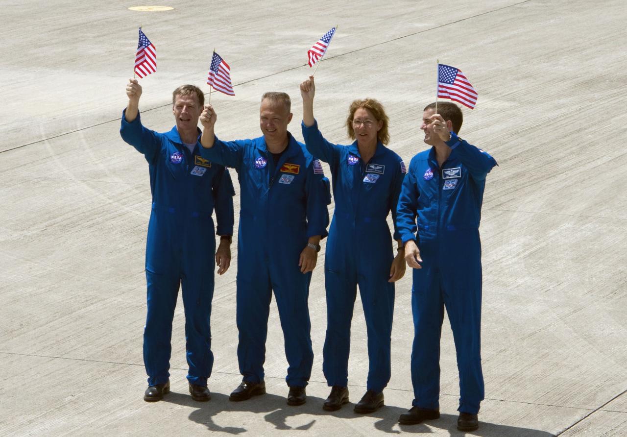 CAPE CANAVERAL, Fla. -- On the Shuttle Landing Facility at NASA's Kennedy Space Center in Florida, the STS-135 crew wave an American flag that commemorates the U.S. Independence Day holiday. From left are Commander Chris Ferguson, Pilot Doug Hurley and Mission Specialists Sandy Magnus and Rex Walheim. The STS-135 astronauts arrived at Kennedy about 2:30 p.m. EDT on July 4 for final preparations for space shuttle Atlantis' STS-135 mission to the International Space Station. Atlantis is scheduled to lift off on July 8 to deliver the Raffaello multi-purpose logistics module packed with supplies and spare parts to the station. The STS-135 mission also will fly a system to investigate the potential for robotically refueling existing satellites and return a failed ammonia pump module to help NASA better understand the failure mechanism and improve pump designs for future systems. STS-135 will be the 33rd flight of Atlantis, the 37th shuttle mission to the space station, and the 135th and final mission of NASA's Space Shuttle Program. For more information visit, www.nasa.gov/mission_pages/shuttle/shuttlemissions/sts135/index.html. Photo credit: NASA/Ken Thornsley