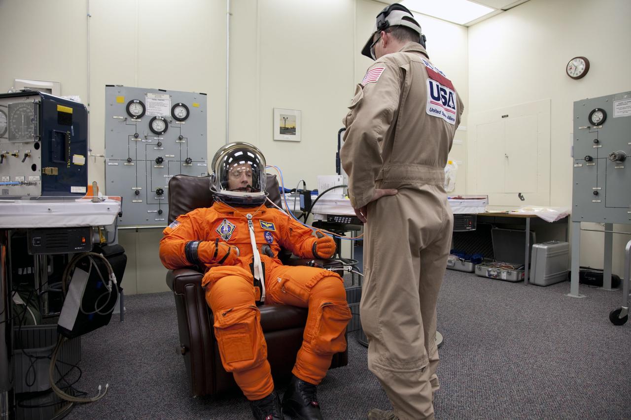 CAPE CANAVERAL, Fla. -- In the Operations and Checkout Building at NASA's Kennedy Space Center in Florida, STS-135 Commander Chris Ferguson has his launch-and-landing suit checked by a suit technician, part of final preparations for space shuttle Atlantis' STS-135 mission to the International Space Station. Atlantis and its crew are scheduled to lift off at 11:26 a.m. EDT on July 8 to deliver the Raffaello multi-purpose logistics module packed with supplies and spare parts to the station. The STS-135 mission also will fly a system to investigate the potential for robotically refueling existing satellites and return a failed ammonia pump module to help NASA better understand the failure mechanism and improve pump designs for future systems. STS-135 will be the 33rd flight of Atlantis, the 37th shuttle mission to the space station, and the 135th and final mission of NASA's Space Shuttle Program. For more information visit, www.nasa.gov/mission_pages/shuttle/shuttlemissions/sts135/index.html. Photo credit: NASA/Cory Huston