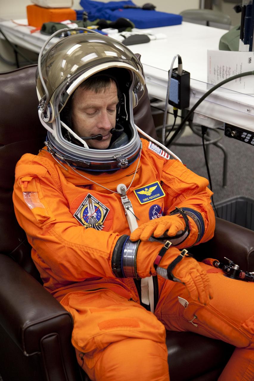 CAPE CANAVERAL, Fla. -- In the Operations and Checkout Building at NASA's Kennedy Space Center in Florida, STS-135 Commander Chris Ferguson checks the fit of his launch-and-landing suit, part of final preparations for space shuttle Atlantis' STS-135 mission to the International Space Station. Atlantis and its crew are scheduled to lift off at 11:26 a.m. EDT on July 8 to deliver the Raffaello multi-purpose logistics module packed with supplies and spare parts to the station. The STS-135 mission also will fly a system to investigate the potential for robotically refueling existing satellites and return a failed ammonia pump module to help NASA better understand the failure mechanism and improve pump designs for future systems. STS-135 will be the 33rd flight of Atlantis, the 37th shuttle mission to the space station, and the 135th and final mission of NASA's Space Shuttle Program. For more information visit, www.nasa.gov/mission_pages/shuttle/shuttlemissions/sts135/index.html. Photo credit: NASA/Cory Huston