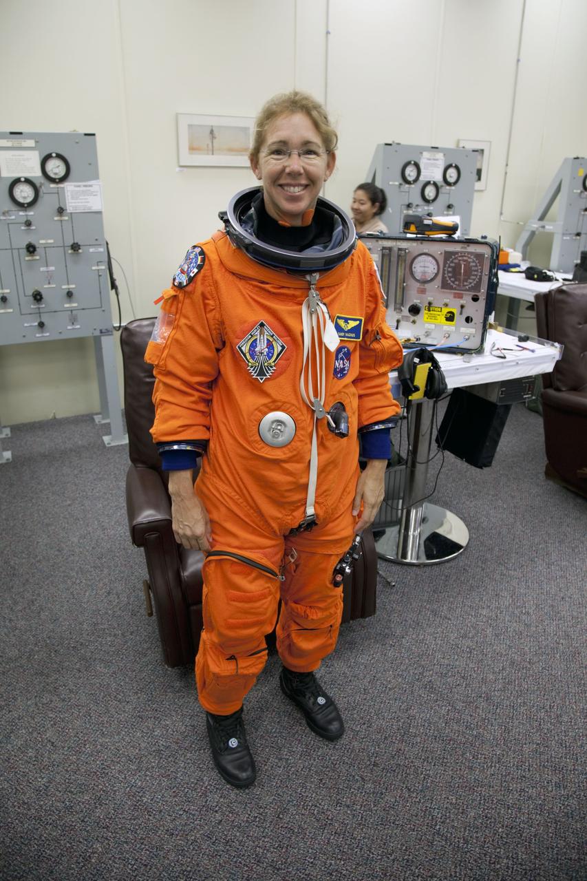 CAPE CANAVERAL, Fla. -- In the Operations and Checkout Building at NASA's Kennedy Space Center in Florida, STS-135 Mission Specialist Sandy Magnus pauses for a photo after checking the fit of her launch-and-landing suit, part of final preparations for space shuttle Atlantis' STS-135 mission to the International Space Station. Atlantis and its crew are scheduled to lift off at 11:26 a.m. EDT on July 8 to deliver the Raffaello multi-purpose logistics module packed with supplies and spare parts to the station. The STS-135 mission also will fly a system to investigate the potential for robotically refueling existing satellites and return a failed ammonia pump module to help NASA better understand the failure mechanism and improve pump designs for future systems. STS-135 will be the 33rd flight of Atlantis, the 37th shuttle mission to the space station, and the 135th and final mission of NASA's Space Shuttle Program. For more information visit, www.nasa.gov/mission_pages/shuttle/shuttlemissions/sts135/index.html. Photo credit: NASA/Cory Huston