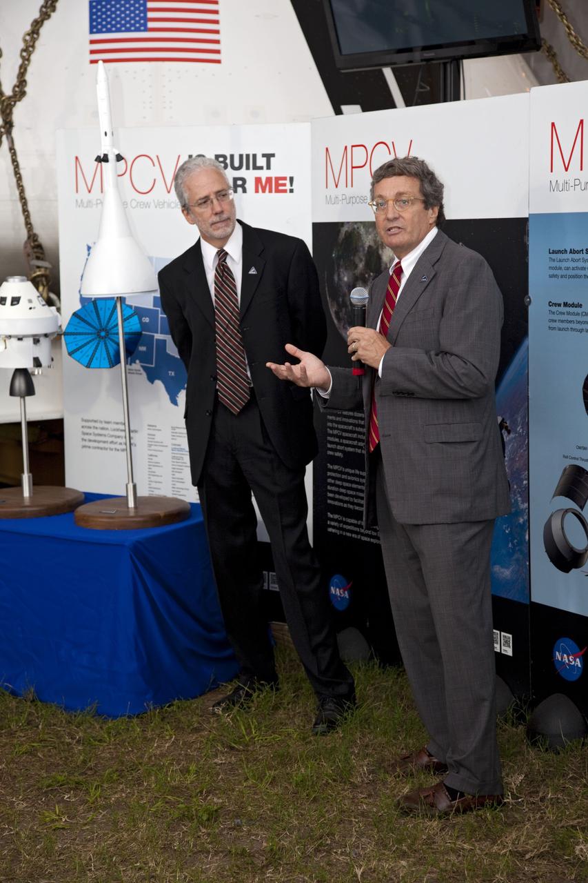 CAPE CANAVERAL, Fla. -- A media event was held on the grounds near the Press Site at NASA's Kennedy Space Center in Florida where a Multi-Purpose Crew Vehicle (MPCV) is on display. The MPCV is based on the Orion design requirements for traveling beyond low Earth orbit and will serve as the exploration vehicle that will carry the crew to space, provide emergency abort capability, sustain the crew during the space travel, and provide safe re-entry from deep space return velocities. Seen here is Mark Geyer, Multi-Purpose Crew Vehicle program manager (left) and Laurence A. Price, Orion deputy program manager with Lockheed Martin Space Systems Company speaking to media during a question-and-answer session. Photo credit: NASA/Frankie Martin