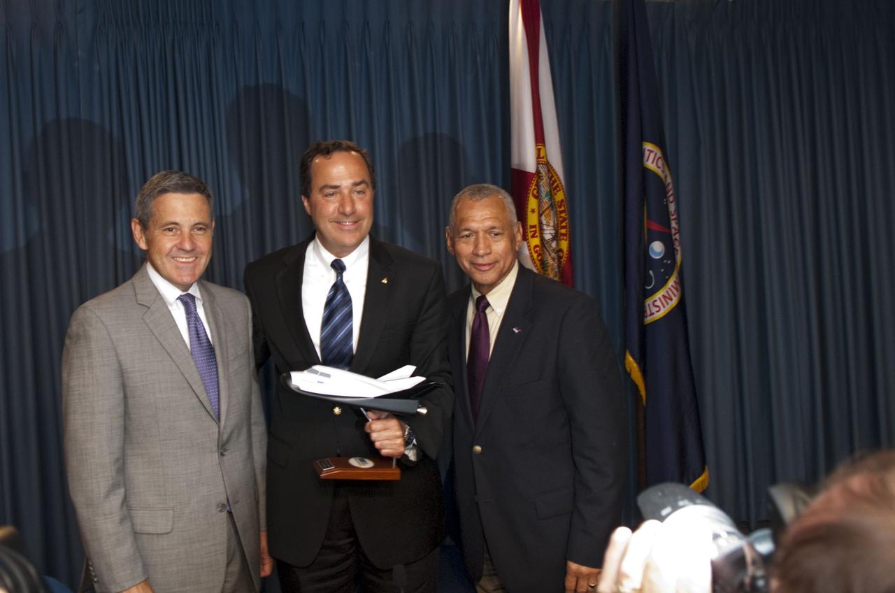 CAPE CANAVERAL, Fla. -- Kennedy Space Center Director Bob Cabana, left, Mark Sirangelo, head of Sierra Nevada Space Systems (SNSS) of Sparks, Nev., and NASA Administrator Charlie Bolden pose for a photo after signing a Space Act Agreement that will offer the company technical capabilities from Kennedy's uniquely skilled work force. Kennedy will help Sierra Nevada with the ground operations support of its lifting body reusable spacecraft called "Dream Chaser," which resembles a smaller version of the space shuttle orbiter.    The spacecraft would carry as many as seven astronauts to the space station. Through the new agreement, Kennedy's work force will use its experience of processing the shuttle fleet for 30 years to help Sierra Nevada define and execute Dream Chaser's launch preparations and post-landing activities. In 2010 and 2011, Sierra Nevada was awarded grants as part of the initiative to stimulate the private sector in developing and demonstrating human spaceflight capabilities for NASA's Commercial Crew Program. The goal of the program, which is based in Florida at Kennedy, is to facilitate the development of a U.S. commercial crew space transportation capability by achieving safe, reliable and cost-effective access to and from the space station and future low Earth orbit destinations. Photo credit: NASA/Jim Grossmann