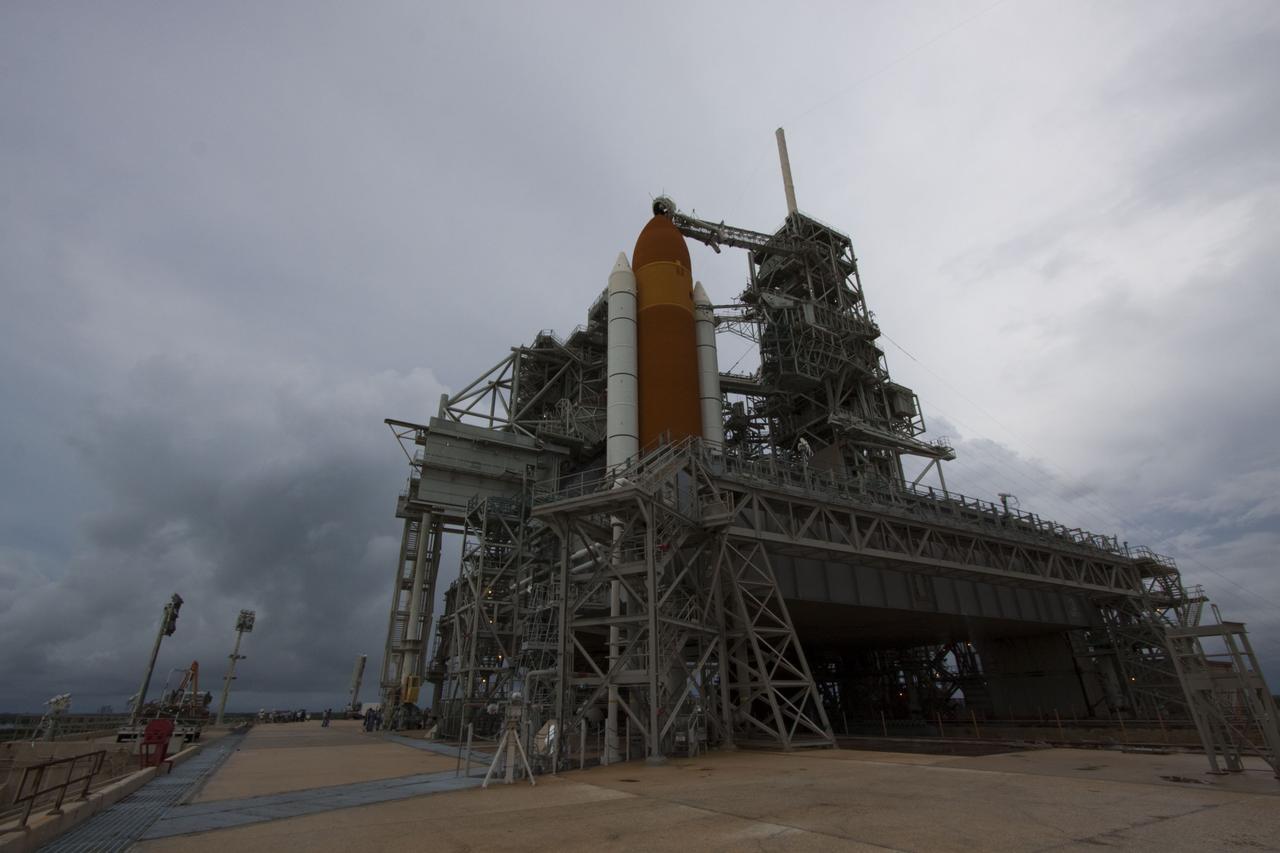 CAPE CANAVERAL, Fla. -- On a cloudy and overcast day on Launch Pad 39A at NASA's Kennedy Space Center in Florida, workers prepare to roll the rotating service structure (RSS) away from space shuttle Atlantis. The RSS provides weather protection and access to the shuttle while it awaits liftoff. RSS "rollback" marks a major milestone in Atlantis' STS-135 mission countdown.          Atlantis and its crew of four; Commander Chris Ferguson, Pilot Doug Hurley and Mission Specialists Sandy Magnus and Rex Walheim, are scheduled to lift off at 11:26 a.m. EDT on July 8 to deliver the Raffaello multi-purpose logistics module packed with supplies and spare parts to the International Space Station. Atlantis also will fly the Robotic Refueling Mission experiment that will investigate the potential for robotically refueling existing satellites in orbit. In addition, Atlantis will return with a failed ammonia pump module to help NASA better understand the failure mechanism and improve pump designs for future systems. STS-135 will be the 33rd flight of Atlantis, the 37th shuttle mission to the space station, and the 135th and final mission of NASA's Space Shuttle Program. For more information visit, www.nasa.gov/mission_pages/shuttle/shuttlemissions/sts135/index.html. Photo credit: NASA/Troy Cryder