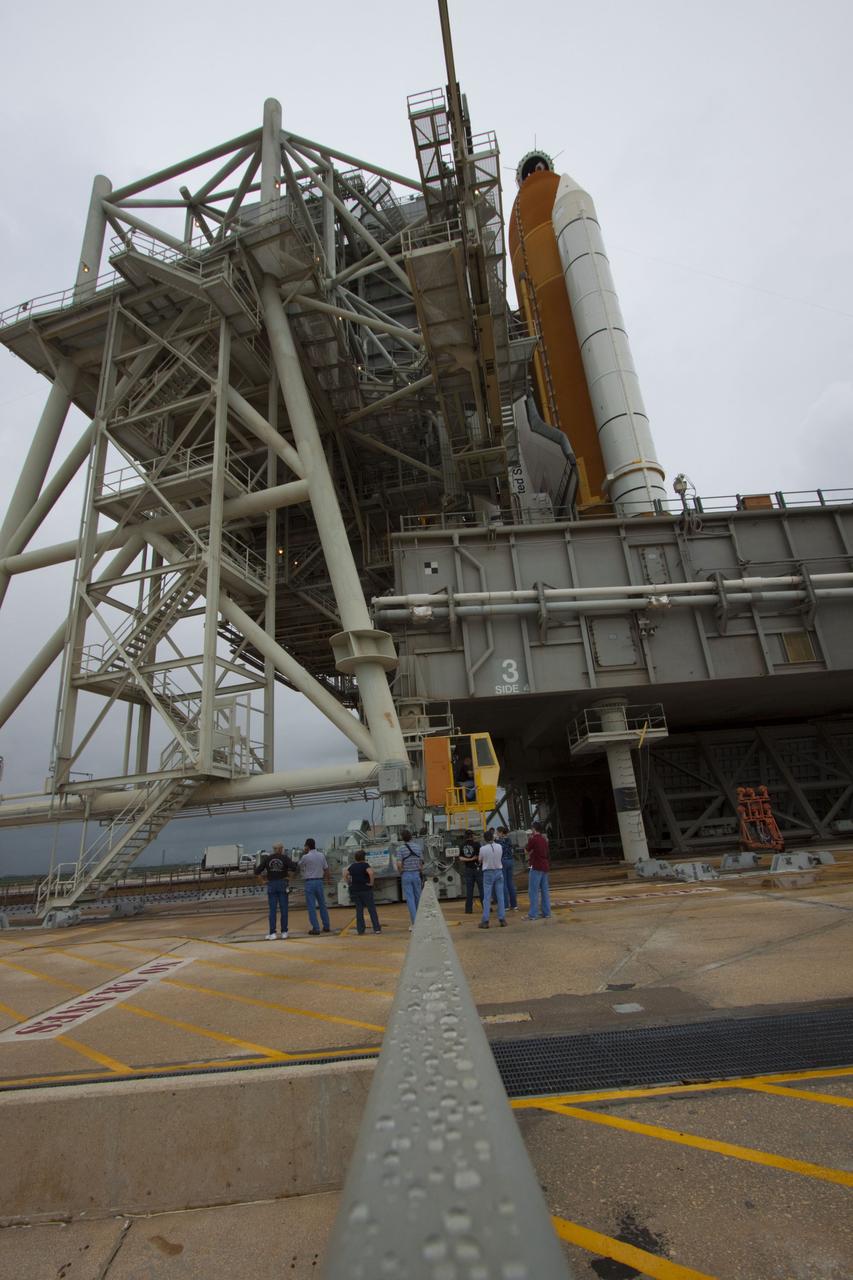 CAPE CANAVERAL, Fla. -- On a cloudy and overcast day on Launch Pad 39A at NASA's Kennedy Space Center in Florida, workers monitor the progress of the rotating service structure (RSS) as it rolls away from space shuttle Atlantis. The RSS provides weather protection and access to the shuttle while it awaits liftoff. RSS "rollback" marks a major milestone in Atlantis' STS-135 mission countdown.      Atlantis and its crew of four; Commander Chris Ferguson, Pilot Doug Hurley and Mission Specialists Sandy Magnus and Rex Walheim, are scheduled to lift off at 11:26 a.m. EDT on July 8 to deliver the Raffaello multi-purpose logistics module packed with supplies and spare parts to the International Space Station. Atlantis also will fly the Robotic Refueling Mission experiment that will investigate the potential for robotically refueling existing satellites in orbit. In addition, Atlantis will return with a failed ammonia pump module to help NASA better understand the failure mechanism and improve pump designs for future systems. STS-135 will be the 33rd flight of Atlantis, the 37th shuttle mission to the space station, and the 135th and final mission of NASA's Space Shuttle Program. For more information visit, www.nasa.gov/mission_pages/shuttle/shuttlemissions/sts135/index.html. Photo credit: NASA/Troy Cryder