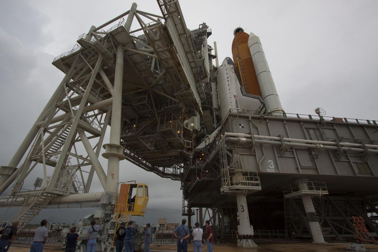 CAPE CANAVERAL, Fla. -- On a cloudy and overcast day on Launch Pad 39A at NASA's Kennedy Space Center in Florida, workers monitor the progress of the rotating service structure (RSS) as it rolls away from space shuttle Atlantis. The RSS provides weather protection and access to the shuttle while it awaits liftoff. RSS "rollback" marks a major milestone in Atlantis' STS-135 mission countdown.      Atlantis and its crew of four; Commander Chris Ferguson, Pilot Doug Hurley and Mission Specialists Sandy Magnus and Rex Walheim, are scheduled to lift off at 11:26 a.m. EDT on July 8 to deliver the Raffaello multi-purpose logistics module packed with supplies and spare parts to the International Space Station. Atlantis also will fly the Robotic Refueling Mission experiment that will investigate the potential for robotically refueling existing satellites in orbit. In addition, Atlantis will return with a failed ammonia pump module to help NASA better understand the failure mechanism and improve pump designs for future systems. STS-135 will be the 33rd flight of Atlantis, the 37th shuttle mission to the space station, and the 135th and final mission of NASA's Space Shuttle Program. For more information visit, www.nasa.gov/mission_pages/shuttle/shuttlemissions/sts135/index.html. Photo credit: NASA/Troy Cryder