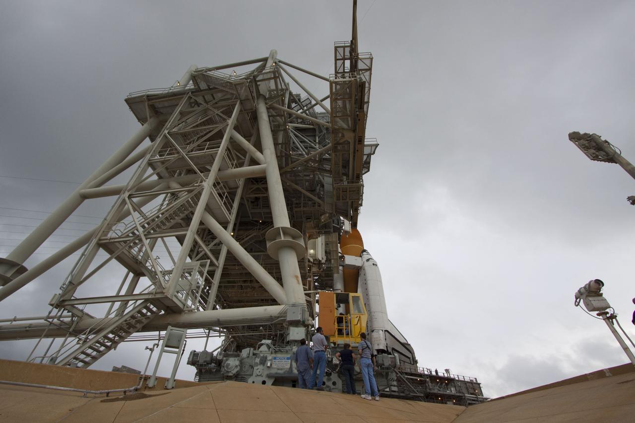 CAPE CANAVERAL, Fla. -- Workers check out space shuttle Atlantis after it was uncovered on Launch Pad 39A at NASA's Kennedy Space Center in Florida following the move of the rotating service structure (RSS). The structure provides weather protection and access to the shuttle while it awaits liftoff on the pad. RSS "rollback" marks a major milestone in Atlantis' STS-135 mission countdown.        Atlantis and its crew of four; Commander Chris Ferguson, Pilot Doug Hurley and Mission Specialists Sandy Magnus and Rex Walheim, are scheduled to lift off at 11:26 a.m. EDT on July 8 to deliver the Raffaello multi-purpose logistics module packed with supplies and spare parts to the International Space Station. Atlantis also will fly the Robotic Refueling Mission experiment that will investigate the potential for robotically refueling existing satellites in orbit. In addition, Atlantis will return with a failed ammonia pump module to help NASA better understand the failure mechanism and improve pump designs for future systems. STS-135 will be the 33rd flight of Atlantis, the 37th shuttle mission to the space station, and the 135th and final mission of NASA's Space Shuttle Program. For more information visit, www.nasa.gov/mission_pages/shuttle/shuttlemissions/sts135/index.html. Photo credit: NASA/Troy Cryder
