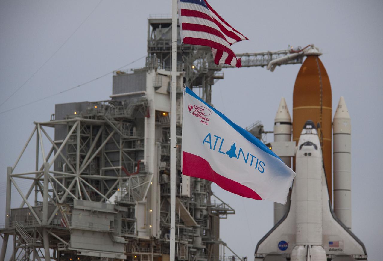 CAPE CANAVERAL, Fla. -- Flags wave briskly at Launch Pad 39A at NASA's Kennedy Space Center in Florida as space shuttle Atlantis is revealed following the move of the rotating service structure (RSS). The structure provides weather protection and access to the shuttle while it awaits liftoff on the pad. RSS "rollback" marks a major milestone in Atlantis' STS-135 mission countdown.        Atlantis and its crew of four; Commander Chris Ferguson, Pilot Doug Hurley and Mission Specialists Sandy Magnus and Rex Walheim, are scheduled to lift off at 11:26 a.m. EDT on July 8 to deliver the Raffaello multi-purpose logistics module packed with supplies and spare parts to the International Space Station. Atlantis also will fly the Robotic Refueling Mission experiment that will investigate the potential for robotically refueling existing satellites in orbit. In addition, Atlantis will return with a failed ammonia pump module to help NASA better understand the failure mechanism and improve pump designs for future systems. STS-135 will be the 33rd flight of Atlantis, the 37th shuttle mission to the space station, and the 135th and final mission of NASA's Space Shuttle Program. For more information visit, www.nasa.gov/mission_pages/shuttle/shuttlemissions/sts135/index.html. Photo credit: NASA/Troy Cryder