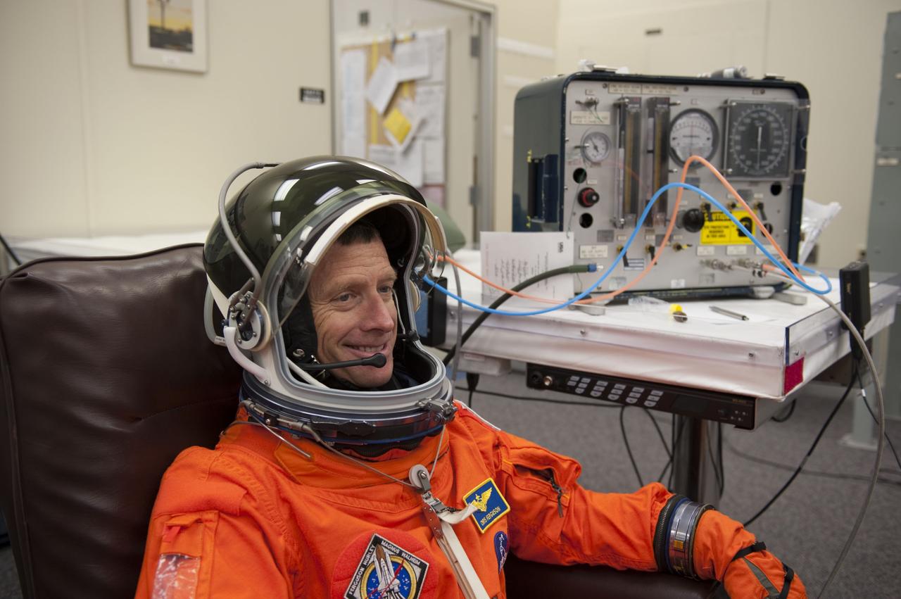 CAPE CANAVERAL, Fla. -- STS-135 Commander Chris Ferguson dons his launch-and-entry suit and helmet in the Operations and Checkout Building at NASA's Kennedy Space Center in Florida. Ferguson is one of the final four astronauts to launch aboard a space shuttle. He is a retired U.S. Navy captain who already has logged nearly a month in space during two previous shuttle flights. STS-135 is scheduled to lift off aboard space shuttle Atlantis at 11:26 a.m. EDT on July 8 for a mission to the International Space Station.        STS-135 will deliver the Raffaello multi-purpose logistics module packed with supplies and spare parts for the orbiting outpost. Atlantis also will fly the Robotic Refueling Mission experiment that will investigate the potential for robotically refueling existing satellites in orbit. In addition, Atlantis will return with a failed ammonia pump module to help NASA better understand the failure mechanism and improve pump designs for future systems. STS-135 will be the 33rd flight of Atlantis, the 37th shuttle mission to the space station, and the 135th and final mission of NASA's Space Shuttle Program. For more information visit, www.nasa.gov/mission_pages/shuttle/shuttlemissions/sts135/index.html. Photo credit: NASA/Kim Shiflett