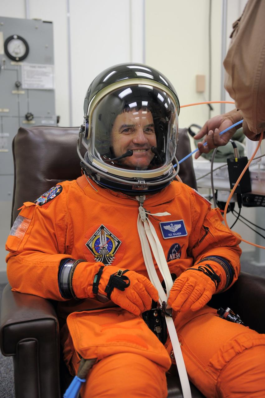 CAPE CANAVERAL, Fla. -- STS-135 Mission Specialist Rex Walheim dons his launch-and-entry suit and helmet in the Operations and Checkout Building at NASA's Kennedy Space Center in Florida. Walheim is one of the final four astronauts to launch aboard a space shuttle. All three of Walheim's missions -- STS-110, STS-122 and now STS-135 -- will have been aboard space shuttle Atlantis. STS-135 is scheduled to lift off aboard Atlantis at 11:26 a.m. EDT on July 8 for a mission to the International Space Station.    STS-135 will deliver the Raffaello multi-purpose logistics module packed with supplies and spare parts for the orbiting outpost. Atlantis also will fly the Robotic Refueling Mission experiment that will investigate the potential for robotically refueling existing satellites in orbit. In addition, Atlantis will return with a failed ammonia pump module to help NASA better understand the failure mechanism and improve pump designs for future systems. STS-135 will be the 33rd flight of Atlantis, the 37th shuttle mission to the space station, and the 135th and final mission of NASA's Space Shuttle Program. For more information visit, www.nasa.gov/mission_pages/shuttle/shuttlemissions/sts135/index.html. Photo credit: NASA/Kim Shiflett