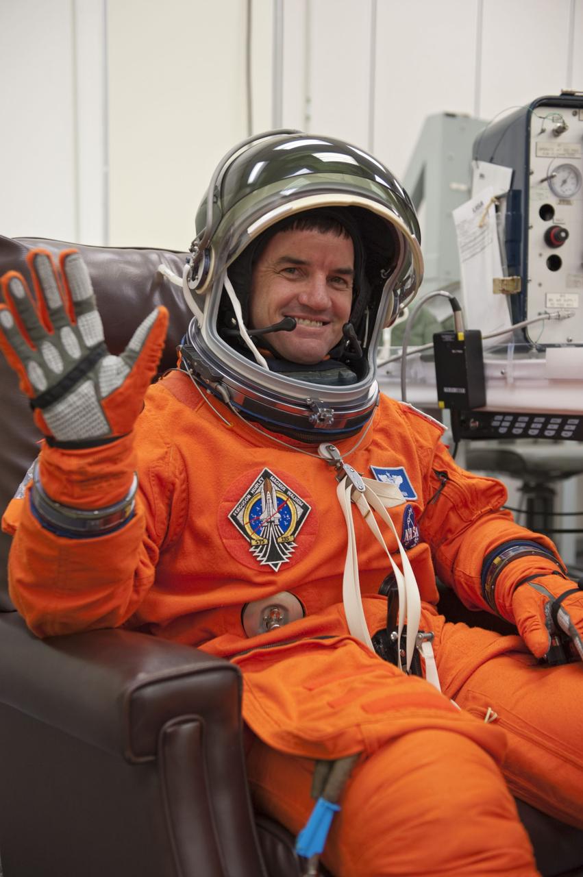 CAPE CANAVERAL, Fla. -- STS-135 Mission Specialist Rex Walheim waves as he dons his launch-and-entry suit and helmet in the Operations and Checkout Building at NASA's Kennedy Space Center in Florida. Walheim is one of the final four astronauts to launch aboard a space shuttle. All three of Walheim's missions -- STS-110, STS-122 and now STS-135 -- will have been aboard space shuttle Atlantis. STS-135 is scheduled to lift off aboard Atlantis at 11:26 a.m. EDT on July 8 for a mission to the International Space Station.      STS-135 will deliver the Raffaello multi-purpose logistics module packed with supplies and spare parts for the orbiting outpost. Atlantis also will fly the Robotic Refueling Mission experiment that will investigate the potential for robotically refueling existing satellites in orbit. In addition, Atlantis will return with a failed ammonia pump module to help NASA better understand the failure mechanism and improve pump designs for future systems. STS-135 will be the 33rd flight of Atlantis, the 37th shuttle mission to the space station, and the 135th and final mission of NASA's Space Shuttle Program. For more information visit, www.nasa.gov/mission_pages/shuttle/shuttlemissions/sts135/index.html. Photo credit: NASA/Kim Shiflett