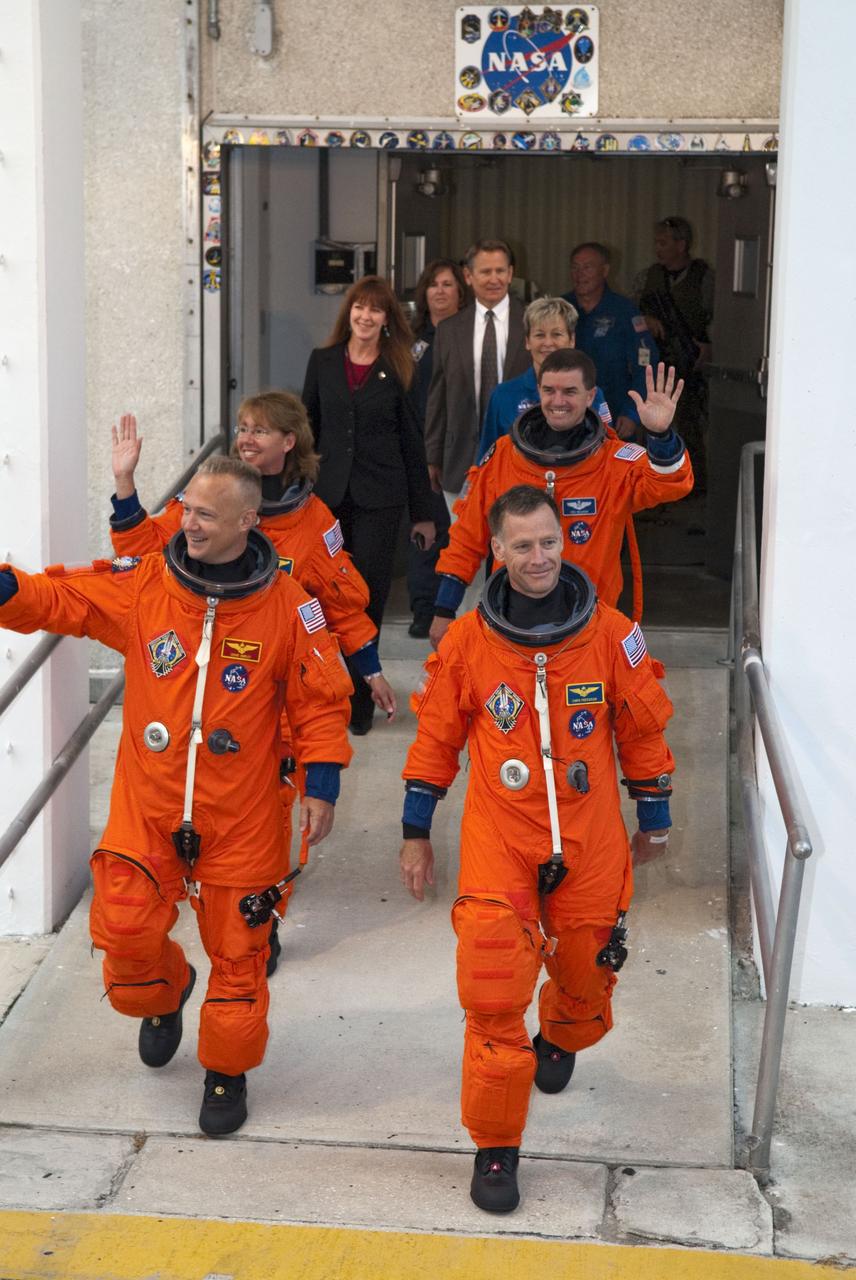 CAPE CANAVERAL, Fla. -- Dressed in their bright-orange launch-and-entry suits, the final four astronauts to launch aboard a space shuttle exit the Astronaut Crew Quarters in the Operations and Checkout Building at NASA's Kennedy Space Center in Florida. In the left row, STS-135 Pilot Doug Hurley is followed by Mission Specialist Sandy Magnus. In the right row, Commander Chris Ferguson is followed by Mission Specialist Rex Walheim. The astronauts, who will head to Launch Pad 39A aboard the silver Astrovan, are scheduled to lift off aboard space shuttle Atlantis at 11:26 a.m. EDT on July 8 for their mission to the International Space Station.    STS-135 will deliver the Raffaello multi-purpose logistics module packed with supplies and spare parts for the orbiting outpost. Atlantis also will fly the Robotic Refueling Mission experiment that will investigate the potential for robotically refueling existing satellites in orbit. In addition, Atlantis will return with a failed ammonia pump module to help NASA better understand the failure mechanism and improve pump designs for future systems. STS-135 will be the 33rd flight of Atlantis, the 37th shuttle mission to the space station, and the 135th and final mission of NASA's Space Shuttle Program. For more information, visit www.nasa.gov/mission_pages/shuttle/shuttlemissions/sts135/index.html. Photo credit: NASA/Kim Shiflett