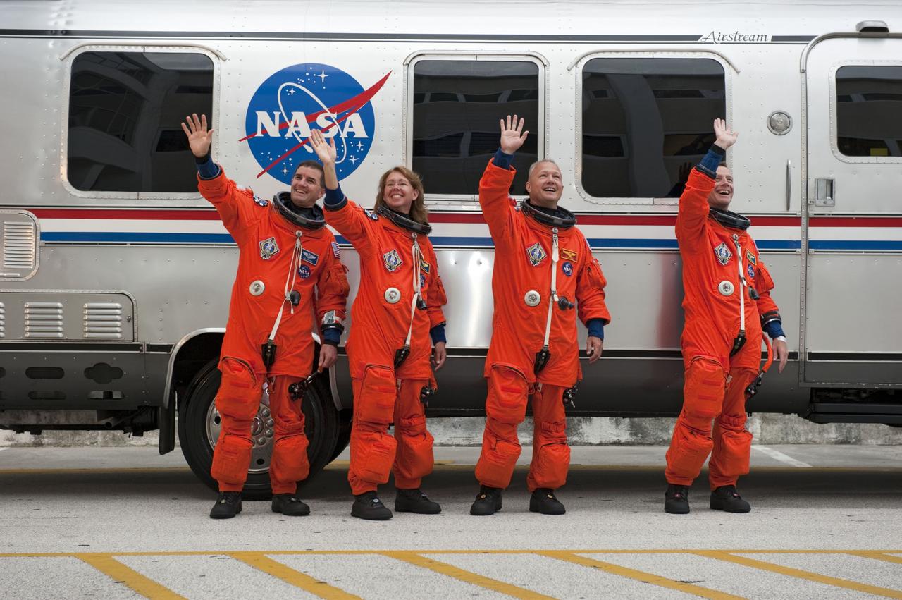 CAPE CANAVERAL, Fla. -- Dressed in their bright-orange launch-and-entry suits, the final four astronauts to launch aboard a space shuttle wave to media and employees cheering them on in front of the Astronaut Crew Quarters in the Operations and Checkout Building at NASA's Kennedy Space Center in Florida. From left, are STS-135 Mission Specialists Rex Walheim and Sandy Magnus, Pilot Doug Hurley, and Commander Chris Ferguson. The silver Astrovan will take the astronauts to Launch Pad 39A, where they will board space shuttle Atlantis for a scheduled liftoff at 11:26 a.m. EDT on July 8 for their mission to the International Space Station.    STS-135 will deliver the Raffaello multi-purpose logistics module packed with supplies and spare parts for the orbiting outpost. Atlantis also will fly the Robotic Refueling Mission experiment that will investigate the potential for robotically refueling existing satellites in orbit. In addition, Atlantis will return with a failed ammonia pump module to help NASA better understand the failure mechanism and improve pump designs for future systems. STS-135 will be the 33rd flight of Atlantis, the 37th shuttle mission to the space station, and the 135th and final mission of NASA's Space Shuttle Program. For more information, visit www.nasa.gov/mission_pages/shuttle/shuttlemissions/sts135/index.html. Photo credit: NASA/Kim Shiflett