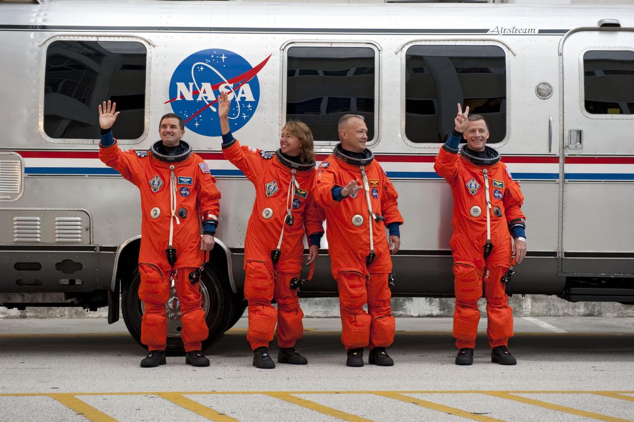 CAPE CANAVERAL, Fla. -- Dressed in their bright-orange launch-and-entry suits, the final four astronauts to launch aboard a space shuttle wave to media and employees cheering them on in front of the Astronaut Crew Quarters in the Operations and Checkout Building at NASA's Kennedy Space Center in Florida. From left, are STS-135 Mission Specialists Rex Walheim and Sandy Magnus, Pilot Doug Hurley, and Commander Chris Ferguson. The silver Astrovan will take the astronauts to Launch Pad 39A, where they will board space shuttle Atlantis for a scheduled liftoff at 11:26 a.m. EDT on July 8 for their mission to the International Space Station.    STS-135 will deliver the Raffaello multi-purpose logistics module packed with supplies and spare parts for the orbiting outpost. Atlantis also will fly the Robotic Refueling Mission experiment that will investigate the potential for robotically refueling existing satellites in orbit. In addition, Atlantis will return with a failed ammonia pump module to help NASA better understand the failure mechanism and improve pump designs for future systems. STS-135 will be the 33rd flight of Atlantis, the 37th shuttle mission to the space station, and the 135th and final mission of NASA's Space Shuttle Program. For more information, visit www.nasa.gov/mission_pages/shuttle/shuttlemissions/sts135/index.html. Photo credit: NASA/Kim Shiflett