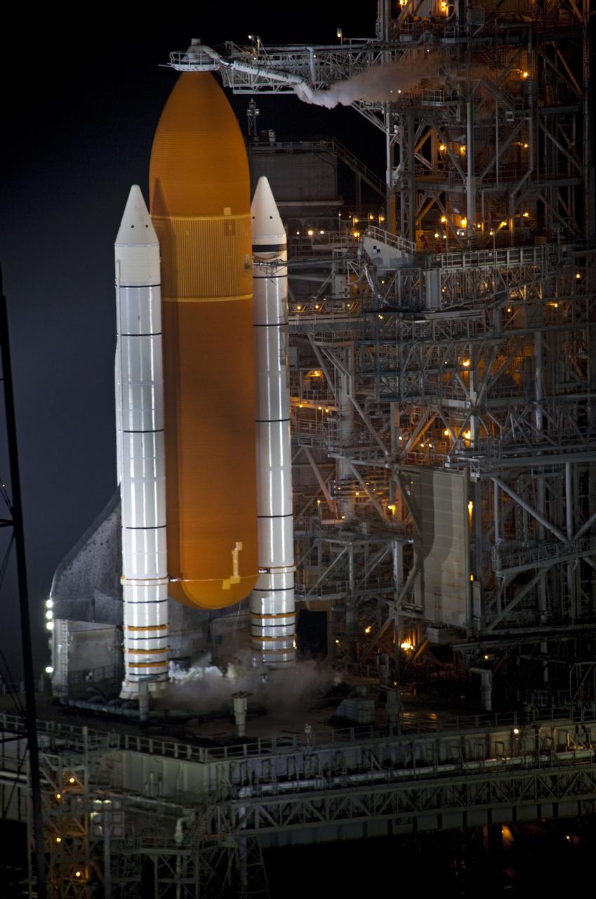 CAPE CANAVERAL, Fla. -- A NASA helicopter circles space shuttle Atlantis on Launch Pad 39A prior to launch on the STS-135 mission. To the right of the shuttle, the fixed service structure which is normally closed around the shuttle now is open for liftoff. At left of the pad is the 300,000-gallon water tower that provides the water used for sound suppression on the pad during liftoff.    Atlantis and its crew of four -- Commander Chris Ferguson, Pilot Doug Hurley and Mission Specialists Sandy Magnus and Rex Walheim -- are scheduled to lift off at 11:26 a.m. EDT on July 8 to deliver the Raffaello multi-purpose logistics module packed with supplies and spare parts to the International Space Station. Atlantis also will fly the Robotic Refueling Mission experiment that will investigate the potential for robotically refueling existing satellites in orbit. In addition, Atlantis will return with a failed ammonia pump module to help NASA better understand the failure mechanism and improve pump designs for future systems. STS-135 will be the 33rd flight of Atlantis, the 37th shuttle mission to the space station, and the 135th and final mission of NASA's Space Shuttle Program. For more information, visit www.nasa.gov/mission_pages/shuttle/shuttlemissions/sts135/index.html. Photo credit: NASA/Frank Michaux