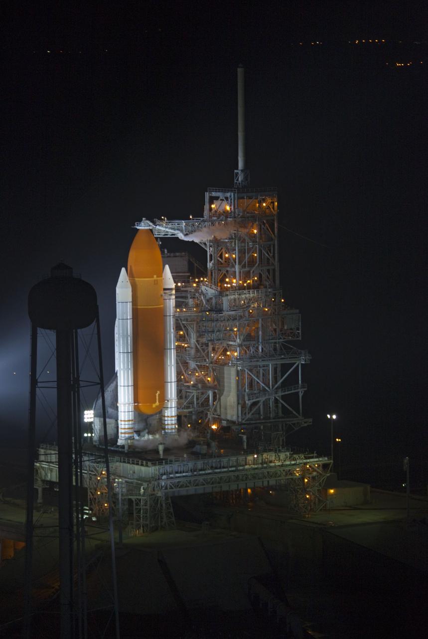 CAPE CANAVERAL, Fla. -- A NASA helicopter circles space shuttle Atlantis on Launch Pad 39A prior to launch on the STS-135 mission. To the right of the shuttle, the fixed service structure which is normally closed around the shuttle now is open for liftoff. At left of the pad is the 300,000-gallon water tower that provides the water used for sound suppression on the pad during liftoff.    Atlantis and its crew of four -- Commander Chris Ferguson, Pilot Doug Hurley and Mission Specialists Sandy Magnus and Rex Walheim -- are scheduled to lift off at 11:26 a.m. EDT on July 8 to deliver the Raffaello multi-purpose logistics module packed with supplies and spare parts to the International Space Station. Atlantis also will fly the Robotic Refueling Mission experiment that will investigate the potential for robotically refueling existing satellites in orbit. In addition, Atlantis will return with a failed ammonia pump module to help NASA better understand the failure mechanism and improve pump designs for future systems. STS-135 will be the 33rd flight of Atlantis, the 37th shuttle mission to the space station, and the 135th and final mission of NASA's Space Shuttle Program. For more information, visit www.nasa.gov/mission_pages/shuttle/shuttlemissions/sts135/index.html. Photo credit: NASA/Frank Michaux