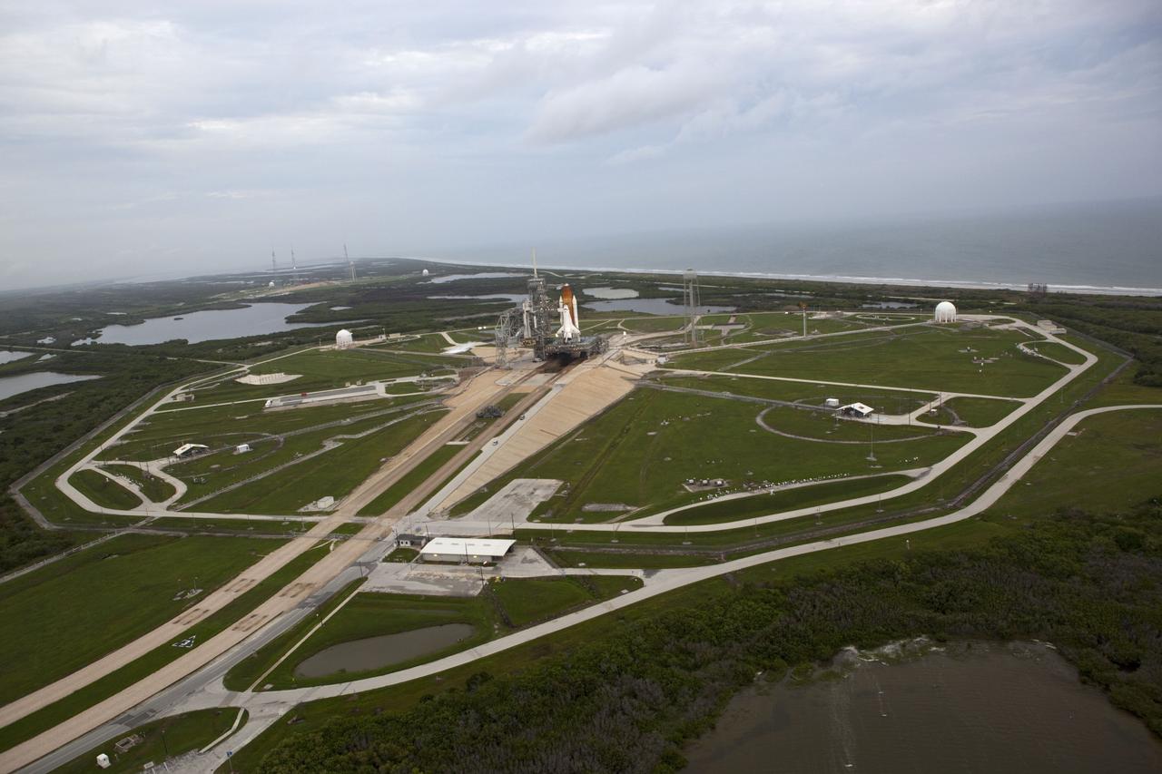 CAPE CANAVERAL, Fla. -- Space shuttle Atlantis, attached to its bright-orange external fuel tank and twin solid rocket boosters, takes center stage on its seaside launch pad at NASA's Kennedy Space Center in Florida in this aerial image taken from a NASA helicopter. Atlantis and its crew of four -- Commander Chris Ferguson, Pilot Doug Hurley and Mission Specialists Sandy Magnus and Rex Walheim -- are scheduled to lift off at 11:26 a.m. EDT on July 8 to deliver the Raffaello multi-purpose logistics module packed with supplies and spare parts to the International Space Station. Atlantis also will fly the Robotic Refueling Mission experiment that will investigate the potential for robotically refueling existing satellites in orbit. In addition, Atlantis will return with a failed ammonia pump module to help NASA better understand the failure mechanism and improve pump designs for future systems. STS-135 will be the 33rd flight of Atlantis, the 37th shuttle mission to the space station, and the 135th and final mission of NASA's Space Shuttle Program. For more information, visit www.nasa.gov/mission_pages/shuttle/shuttlemissions/sts135/index.html. Photo credit: NASA/Frank Michaux