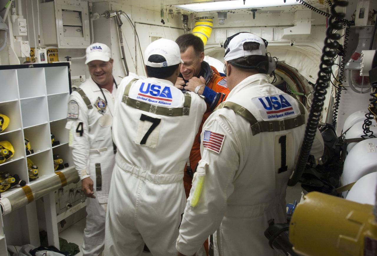 CAPE CANAVERAL, Fla. -- The Closeout Crew helps STS-135 Commander Chris Ferguson prepare to enter space shuttle Atlantis from the White Room of Launch Pad 39A at NASA's Kennedy Space Center in Florida. Ferguson is one of the final four astronauts to launch aboard a space shuttle. He is a retired U.S. Navy captain who already has logged nearly a month in space during two previous shuttle flights. STS-135 is scheduled to lift off at 11:26 a.m. EDT on July 8 for a mission to the International Space Station.    STS-135 will deliver the Raffaello multi-purpose logistics module packed with supplies and spare parts for the International Space Station. Atlantis also will fly the Robotic Refueling Mission experiment that will investigate the potential for robotically refueling existing satellites in orbit. In addition, Atlantis will return with a failed ammonia pump module to help NASA better understand the failure mechanism and improve pump designs for future systems. STS-135 will be the 33rd flight of Atlantis, the 37th shuttle mission to the space station, and the 135th and final mission of NASA's Space Shuttle Program. For more information, visit www.nasa.gov/mission_pages/shuttle/shuttlemissions/sts135/index.html. Photo credit: NASA/Sandra Joseph and Kevin O'Connell