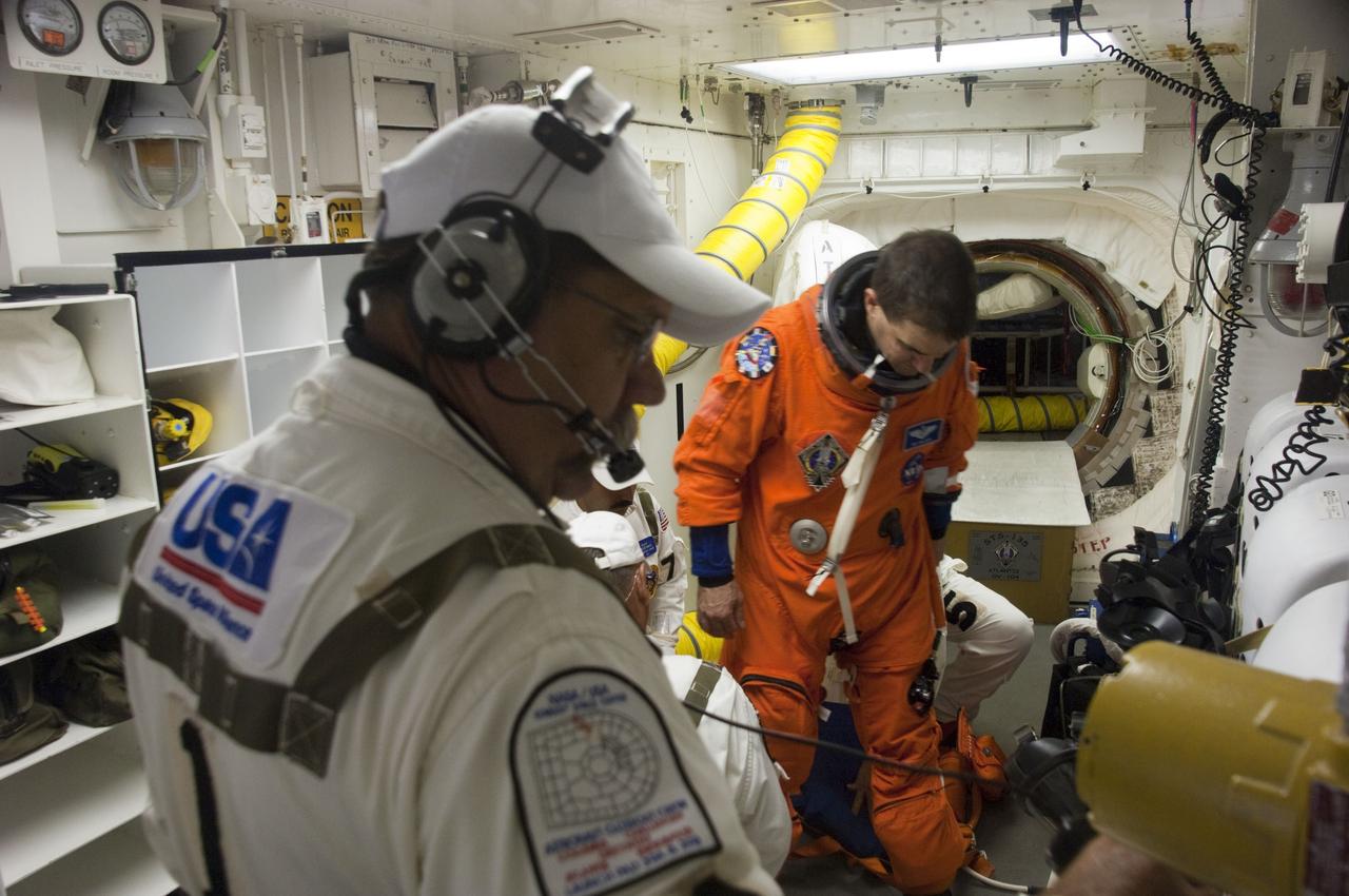 CAPE CANAVERAL, Fla. -- The final astronaut to board a space shuttle for flight, STS-135 Mission Specialist Rex Walheim, is assisted by the Closeout Crew in the White Room of Launch Pad 39A at NASA's Kennedy Space Center in Florida. All three of Walheim's missions -- STS-110, STS-122 and now STS-135 -- will have been aboard space shuttle Atlantis. Four STS-135 crew members are scheduled to lift off at 11:26 a.m. EDT on July 8 for a mission to the International Space Station.      STS-135 will deliver the Raffaello multi-purpose logistics module packed with supplies and spare parts for the International Space Station. Atlantis also will fly the Robotic Refueling Mission experiment that will investigate the potential for robotically refueling existing satellites in orbit. In addition, Atlantis will return with a failed ammonia pump module to help NASA better understand the failure mechanism and improve pump designs for future systems. STS-135 will be the 33rd flight of Atlantis, the 37th shuttle mission to the space station, and the 135th and final mission of NASA's Space Shuttle Program. For more information, visit www.nasa.gov/mission_pages/shuttle/shuttlemissions/sts135/index.html. Photo credit: NASA/Sandra Joseph and Kevin O'Connell