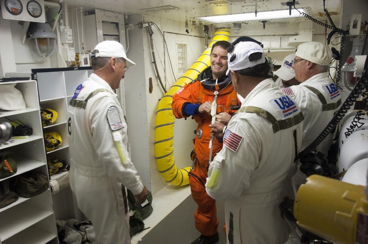 CAPE CANAVERAL, Fla. -- The final astronaut to board a space shuttle for flight, STS-135 Mission Specialist Rex Walheim, bids farewell to the Closeout Crew in the White Room of Launch Pad 39A. All three of Walheim's missions -- STS-110, STS-122 and now STS-135 -- will have been aboard space shuttle Atlantis. Four STS-135 crew members are scheduled to lift off at 11:26 a.m. EDT on July 8 for a mission to the International Space Station.      STS-135 will deliver the Raffaello multi-purpose logistics module packed with supplies and spare parts for the International Space Station. Atlantis also will fly the Robotic Refueling Mission experiment that will investigate the potential for robotically refueling existing satellites in orbit. In addition, Atlantis will return with a failed ammonia pump module to help NASA better understand the failure mechanism and improve pump designs for future systems. STS-135 will be the 33rd flight of Atlantis, the 37th shuttle mission to the space station, and the 135th and final mission of NASA's Space Shuttle Program. For more information, visit www.nasa.gov/mission_pages/shuttle/shuttlemissions/sts135/index.html. Photo credit: NASA/Sandra Joseph and Kevin O'Connell