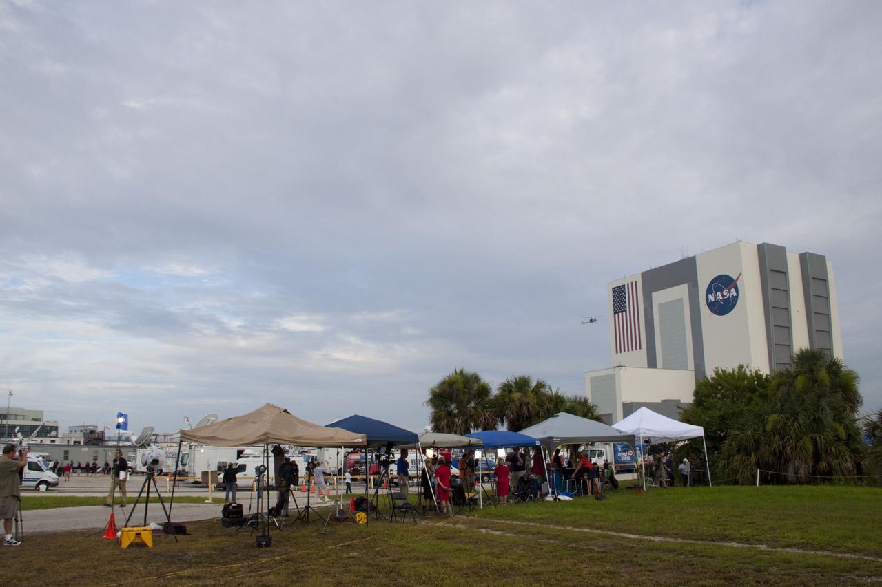 CAPE CANAVERAL, Fla. -- Media from around the globe gather on the grounds of the Press Site at NASA's Kennedy Space Center in Florida to photograph and cover the prelaunch activities and lift off of space shuttle Atlantis on its STS-135 mission to the International Space Station. Dozens of satellite news vehicles can be seen in the parking lot with the massive Vehicle Assembly Building towering above.            Atlantis began its final flight, with Commander Chris Ferguson, Pilot Doug Hurley and Mission Specialists Sandy Magnus and Rex Walheim on board, at 11:29 a.m. EDT July 8 to deliver the Raffaello multi-purpose logistics module packed with supplies and spare parts to the station. Also in Atlantis' payload bay is the Robotic Refueling Mission experiment that will investigate the potential for robotically refueling existing satellites in orbit. In addition, Atlantis will return with a failed ammonia pump module to help NASA better understand the failure mechanism and improve pump designs for future systems. STS-135 is the 33rd flight of Atlantis, the 37th shuttle mission to the space station, and the 135th and final mission of NASA's Space Shuttle Program. For more information, visit www.nasa.gov/mission_pages/shuttle/shuttlemissions/sts135/index.html. Photo credit: NASA/Jim Grossmann