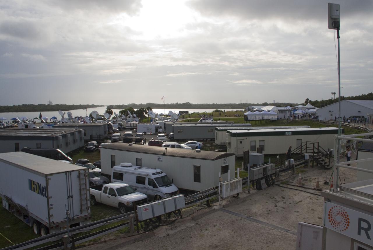 CAPE CANAVERAL, Fla. -- Media from around the globe gather on the grounds of the Press Site at NASA's Kennedy Space Center in Florida to photograph and cover the prelaunch activities and lift off of space shuttle Atlantis on its STS-135 mission to the International Space Station. Seen towering above is the massive Vehicle Assembly Building. Dozens of satellite news vehicles and trailers can be seen in the parking lot. In the background is the Turn Basin where NASA's Pegasus barge delivered the final external tank for the mission.              Atlantis began its final flight, with Commander Chris Ferguson, Pilot Doug Hurley and Mission Specialists Sandy Magnus and Rex Walheim on board, at 11:29 a.m. EDT July 8 to deliver the Raffaello multi-purpose logistics module packed with supplies and spare parts to the station. Also in Atlantis' payload bay is the Robotic Refueling Mission experiment that will investigate the potential for robotically refueling existing satellites in orbit. In addition, Atlantis will return with a failed ammonia pump module to help NASA better understand the failure mechanism and improve pump designs for future systems. STS-135 is the 33rd flight of Atlantis, the 37th shuttle mission to the space station, and the 135th and final mission of NASA's Space Shuttle Program. For more information, visit www.nasa.gov/mission_pages/shuttle/shuttlemissions/sts135/index.html. Photo credit: NASA/Jim Grossmann