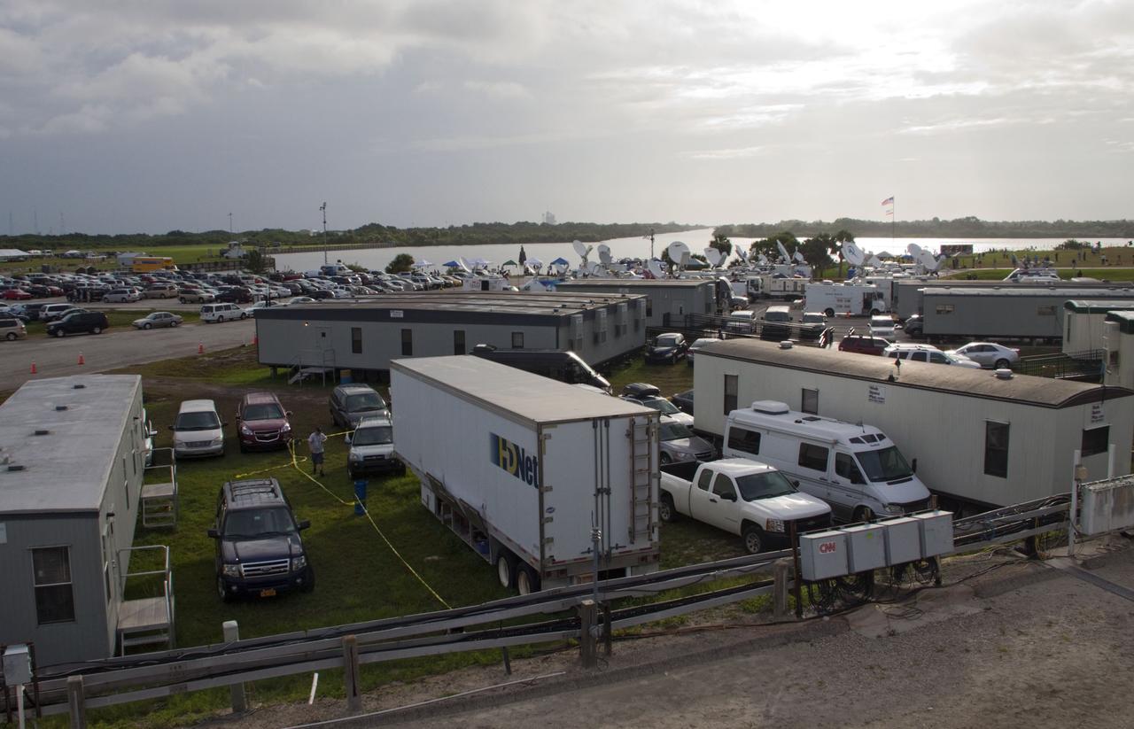 CAPE CANAVERAL, Fla. -- Media from around the globe gather on the grounds of the Press Site at NASA's Kennedy Space Center in Florida to photograph and cover the prelaunch activities and lift off of space shuttle Atlantis on its STS-135 mission to the International Space Station. Seen towering above is the massive Vehicle Assembly Building. Dozens of satellite news vehicles and trailers can be seen in the parking lot. In the background is the Turn Basin where NASA's Pegasus barge delivered the final external tank for the mission.              Atlantis began its final flight, with Commander Chris Ferguson, Pilot Doug Hurley and Mission Specialists Sandy Magnus and Rex Walheim on board, at 11:29 a.m. EDT July 8 to deliver the Raffaello multi-purpose logistics module packed with supplies and spare parts to the station. Also in Atlantis' payload bay is the Robotic Refueling Mission experiment that will investigate the potential for robotically refueling existing satellites in orbit. In addition, Atlantis will return with a failed ammonia pump module to help NASA better understand the failure mechanism and improve pump designs for future systems. STS-135 is the 33rd flight of Atlantis, the 37th shuttle mission to the space station, and the 135th and final mission of NASA's Space Shuttle Program. For more information, visit www.nasa.gov/mission_pages/shuttle/shuttlemissions/sts135/index.html. Photo credit: NASA/Jim Grossmann