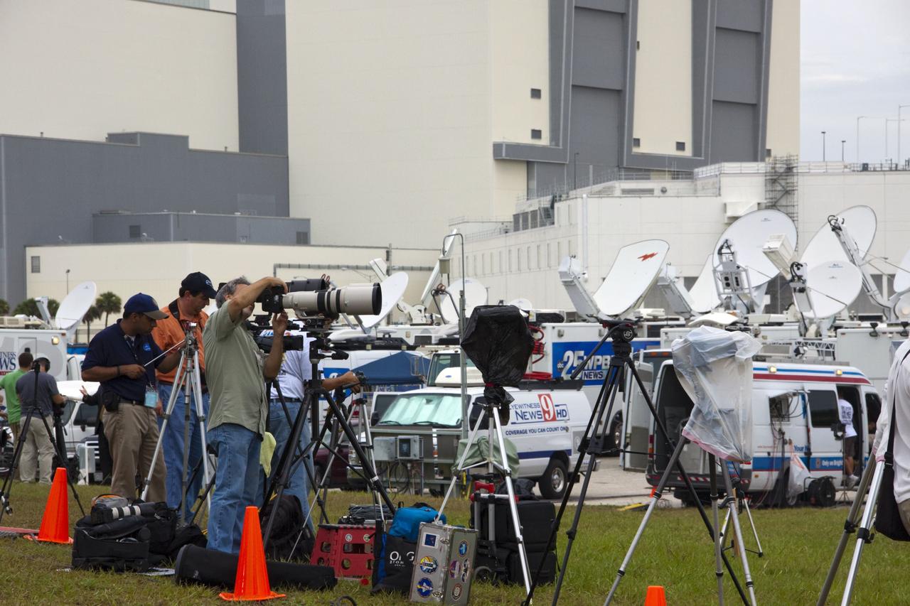 CAPE CANAVERAL, Fla. -- Media from around the globe gather at the NASA News Center at NASA Kennedy Space Center's Press Site in Florida to photograph and cover the prelaunch activities and lift off of space shuttle Atlantis on its STS-135 mission to the International Space Station. Satellite news trucks, trailers and automobiles can be seen in the parking lot with the massive Vehicle Assembly Building towering above.                Atlantis began its final flight, with Commander Chris Ferguson, Pilot Doug Hurley and Mission Specialists Sandy Magnus and Rex Walheim on board, at 11:29 a.m. EDT July 8 to deliver the Raffaello multi-purpose logistics module packed with supplies and spare parts to the station. Also in Atlantis' payload bay is the Robotic Refueling Mission experiment that will investigate the potential for robotically refueling existing satellites in orbit. In addition, Atlantis will return with a failed ammonia pump module to help NASA better understand the failure mechanism and improve pump designs for future systems. STS-135 is the 33rd flight of Atlantis, the 37th shuttle mission to the space station, and the 135th and final mission of NASA's Space Shuttle Program. For more information, visit www.nasa.gov/mission_pages/shuttle/shuttlemissions/sts135/index.html. Photo credit: NASA/Jim Grossmann