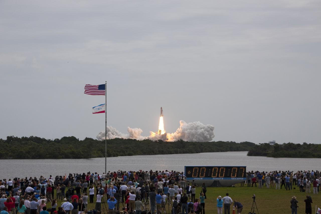 CAPE CANAVERAL, Fla. -- Members of the media and employees gather near the countdown clock to see this rocket's red glare for the last time as space shuttle Atlantis roars off Launch Pad 39A at NASA's Kennedy Space Center in Florida at 11:29 a.m. EDT on July 8. On board are four experienced astronauts -- STS-135 Commander Chris Ferguson, Pilot Doug Hurley, and Mission Specialists Sandy Magnus and Rex Walheim.       STS-135 will deliver the Raffaello multi-purpose logistics module packed with supplies and spare parts for the International Space Station. Atlantis also will fly the Robotic Refueling Mission experiment that will investigate the potential for robotically refueling existing satellites in orbit. In addition, Atlantis will return with a failed ammonia pump module to help NASA better understand the failure mechanism and improve pump designs for future systems. STS-135 will be the 33rd flight of Atlantis, the 37th shuttle mission to the space station, and the 135th and final mission of NASA's Space Shuttle Program. For more information, visit www.nasa.gov/mission_pages/shuttle/shuttlemissions/sts135/index.html. Photo credit: NASA/Jim Grossmann