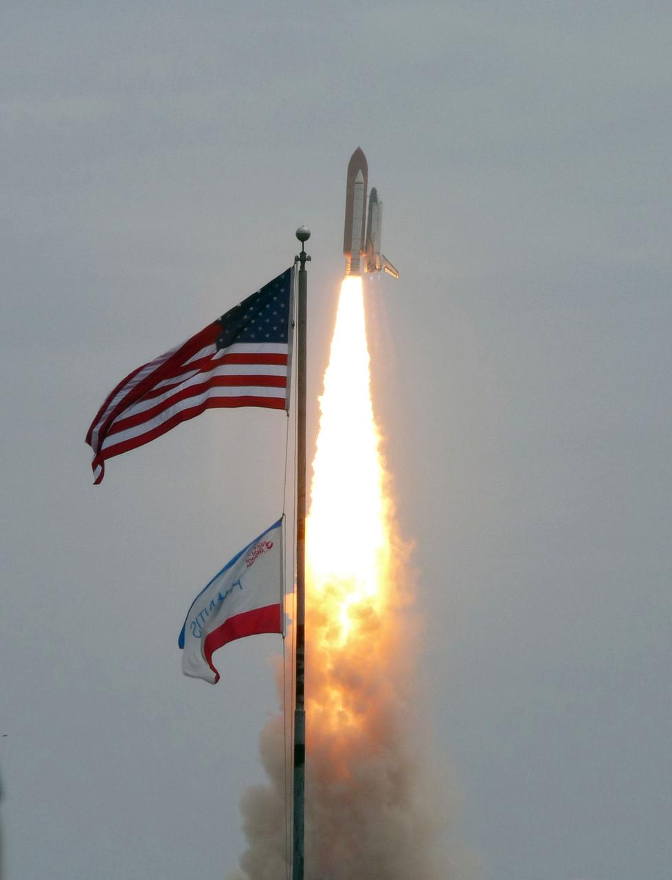 CAPE CANAVERAL, Fla. -- After 30 years and 135 missions, residents and visitors to Florida's Space Coast see this rocket's red glare for the last time as space shuttle Atlantis soars past the American flag after lifting off Launch Pad 39A at NASA's Kennedy Space Center in Florida at 11:29 a.m. EDT on July 8. On board are four experienced astronauts -- STS-135 Commander Chris Ferguson, Pilot Doug Hurley, and Mission Specialists Sandy Magnus and Rex Walheim.       STS-135 will deliver the Raffaello multi-purpose logistics module packed with supplies and spare parts for the International Space Station. Atlantis also will fly the Robotic Refueling Mission experiment that will investigate the potential for robotically refueling existing satellites in orbit. In addition, Atlantis will return with a failed ammonia pump module to help NASA better understand the failure mechanism and improve pump designs for future systems. STS-135 will be the 33rd flight of Atlantis, the 37th shuttle mission to the space station, and the 135th and final mission of NASA's Space Shuttle Program. For more information visit, www.nasa.gov/mission_pages/shuttle/shuttlemissions/sts135/index.html. Photo credit: NASA/Fletcher Hildreth