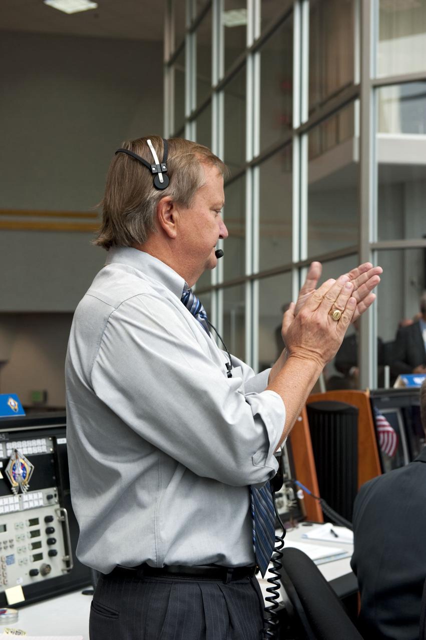 CAPE CANAVERAL, Fla. -- In Firing Room 4 of the Launch Control Center at NASA's Kennedy Space Center in Florida, Shuttle Launch Director Mike Leinbach reacts with applause to the liftoff of space shuttle Atlantis on its STS-135 mission to the International Space Station. Atlantis with its crew of four; Commander Chris Ferguson, Pilot Doug Hurley, Mission Specialists Sandy Magnus and Rex Walheim, lifted off at 11:29 a.m. EDT on July 8, 2011 to deliver the Raffaello multi-purpose logistics module packed with supplies and spare parts for the station. Atlantis also will fly the Robotic Refueling Mission experiment that will investigate the potential for robotically refueling existing satellites in orbit. In addition, Atlantis will return with a failed ammonia pump module to help NASA better understand the failure mechanism and improve pump designs for future systems. STS-135 will be the 33rd flight of Atlantis, the 37th shuttle mission to the space station, and the 135th and final mission of NASA's Space Shuttle Program. For more information, visit www.nasa.gov/mission_pages/shuttle/shuttlemissions/sts135/index.html. Photo credit: NASA/Kim Shiflett