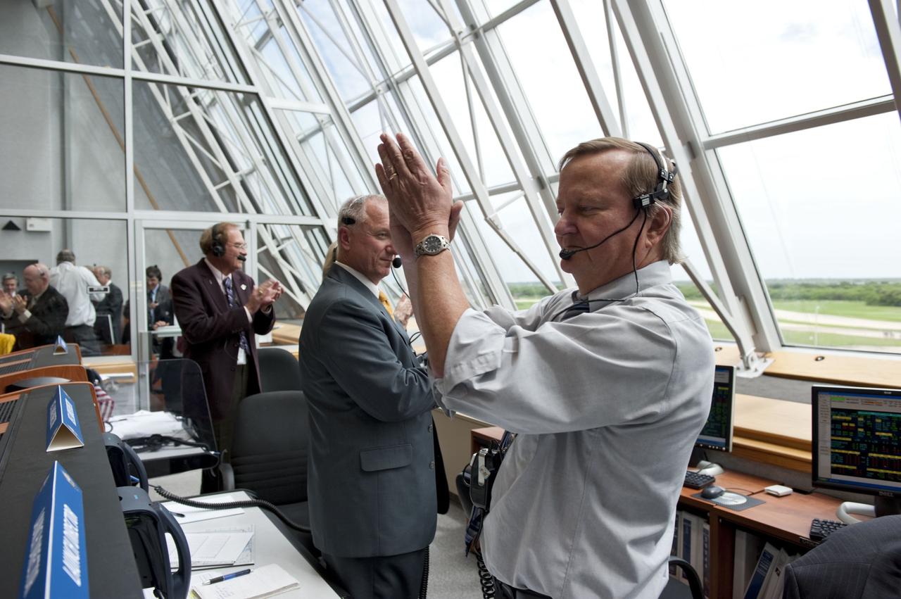 CAPE CANAVERAL, Fla. -- In Firing Room 4 of the Launch Control Center at NASA's Kennedy Space Center in Florida, Shuttle Launch Director Mike Leinbach (right), Assistant Launch Director Pete Nickolenko and NASA Commentator and Public Affairs Officer George Diller applaud the successful launch of space shuttle Atlantis on its STS-135 mission to the International Space Station. Atlantis with its crew of four; Commander Chris Ferguson, Pilot Doug Hurley, Mission Specialists Sandy Magnus and Rex Walheim, lifted off at 11:29 a.m. EDT on July 8, 2011 to deliver the Raffaello multi-purpose logistics module packed with supplies and spare parts for the station. Atlantis also will fly the Robotic Refueling Mission experiment that will investigate the potential for robotically refueling existing satellites in orbit. In addition, Atlantis will return with a failed ammonia pump module to help NASA better understand the failure mechanism and improve pump designs for future systems. STS-135 will be the 33rd flight of Atlantis, the 37th shuttle mission to the space station, and the 135th and final mission of NASA's Space Shuttle Program. For more information, visit www.nasa.gov/mission_pages/shuttle/shuttlemissions/sts135/index.html. Photo credit: NASA/Kim Shiflett
