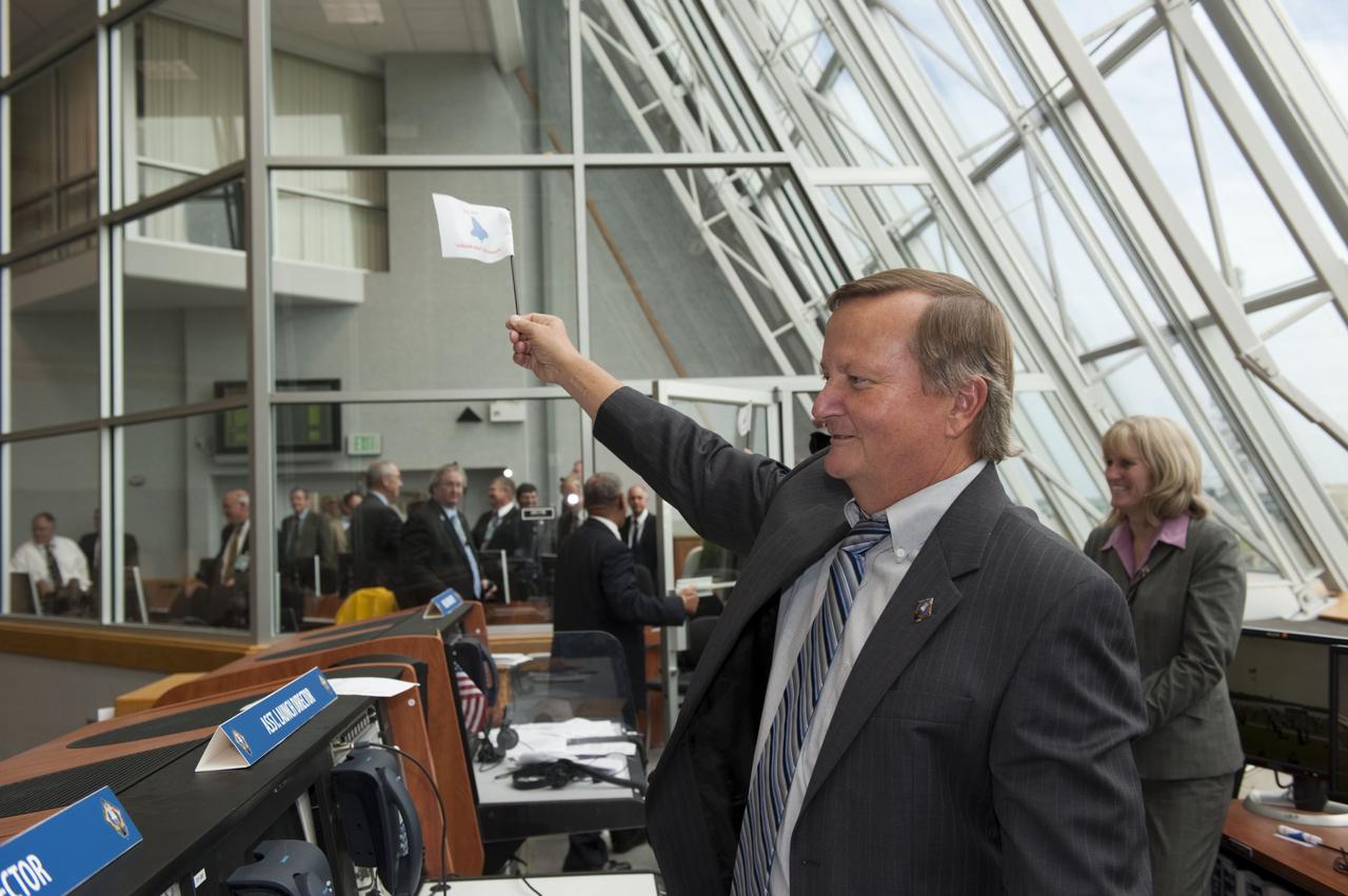 CAPE CANAVERAL, Fla. -- Shuttle Launch Director Mike Leinbach waves his STS-135 shuttle launch team member flag in Firing Room 4 of the Launch Control Center following the successful launch of space shuttle Atlantis from NASA's Kennedy Space Center in Florida. Atlantis began its final flight, the STS-135 mission to the International Space Station, at 11:29 a.m. EDT on July 8. STS-135 will deliver the Raffaello multi-purpose logistics module packed with supplies and spare parts for the International Space Station. Atlantis also is flying the Robotic Refueling Mission experiment that will investigate the potential for robotically refueling existing satellites in orbit. In addition, Atlantis will return with a failed ammonia pump module to help NASA better understand the failure mechanism and improve pump designs for future systems. STS-135 is the 33rd flight of Atlantis, the 37th shuttle mission to the space station, and the 135th and final mission of NASA's Space Shuttle Program. For more information, visit www.nasa.gov/mission_pages/shuttle/shuttlemissions/sts135/index.html. Photo credit: NASA/Kim Shiflett