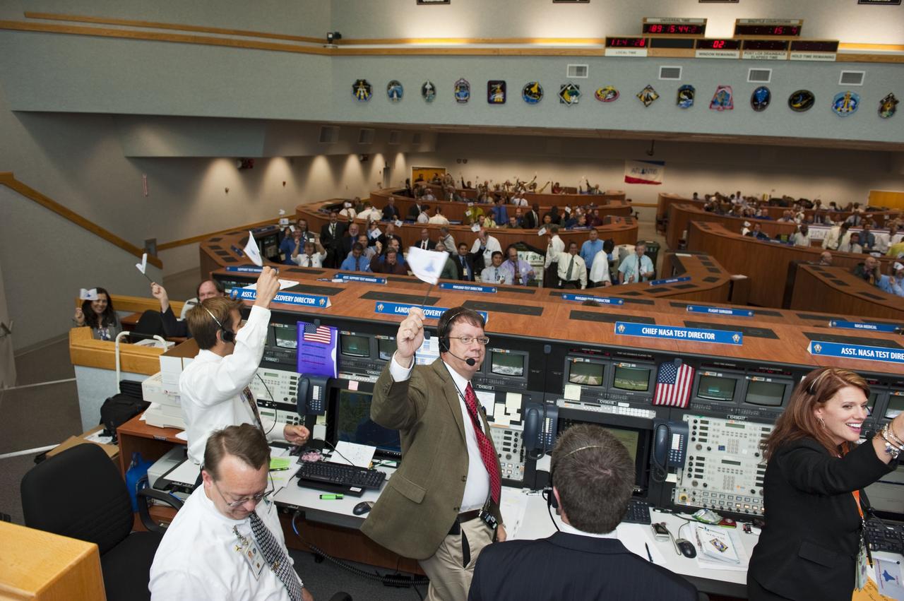 CAPE CANAVERAL, Fla. -- Launch controllers wave their STS-135 shuttle launch team member flags and cheer in Firing Room 4 of the Launch Control Center following the successful launch of space shuttle Atlantis from NASA's Kennedy Space Center in Florida. Atlantis began its final flight, the STS-135 mission to the International Space Station, at 11:29 a.m. EDT on July 8. STS-135 will deliver the Raffaello multi-purpose logistics module packed with supplies and spare parts for the International Space Station. Atlantis also is flying the Robotic Refueling Mission experiment that will investigate the potential for robotically refueling existing satellites in orbit. In addition, Atlantis will return with a failed ammonia pump module to help NASA better understand the failure mechanism and improve pump designs for future systems. STS-135 is the 33rd flight of Atlantis, the 37th shuttle mission to the space station, and the 135th and final mission of NASA's Space Shuttle Program. For more information, visit www.nasa.gov/mission_pages/shuttle/shuttlemissions/sts135/index.html. Photo credit: NASA/Kim Shiflett