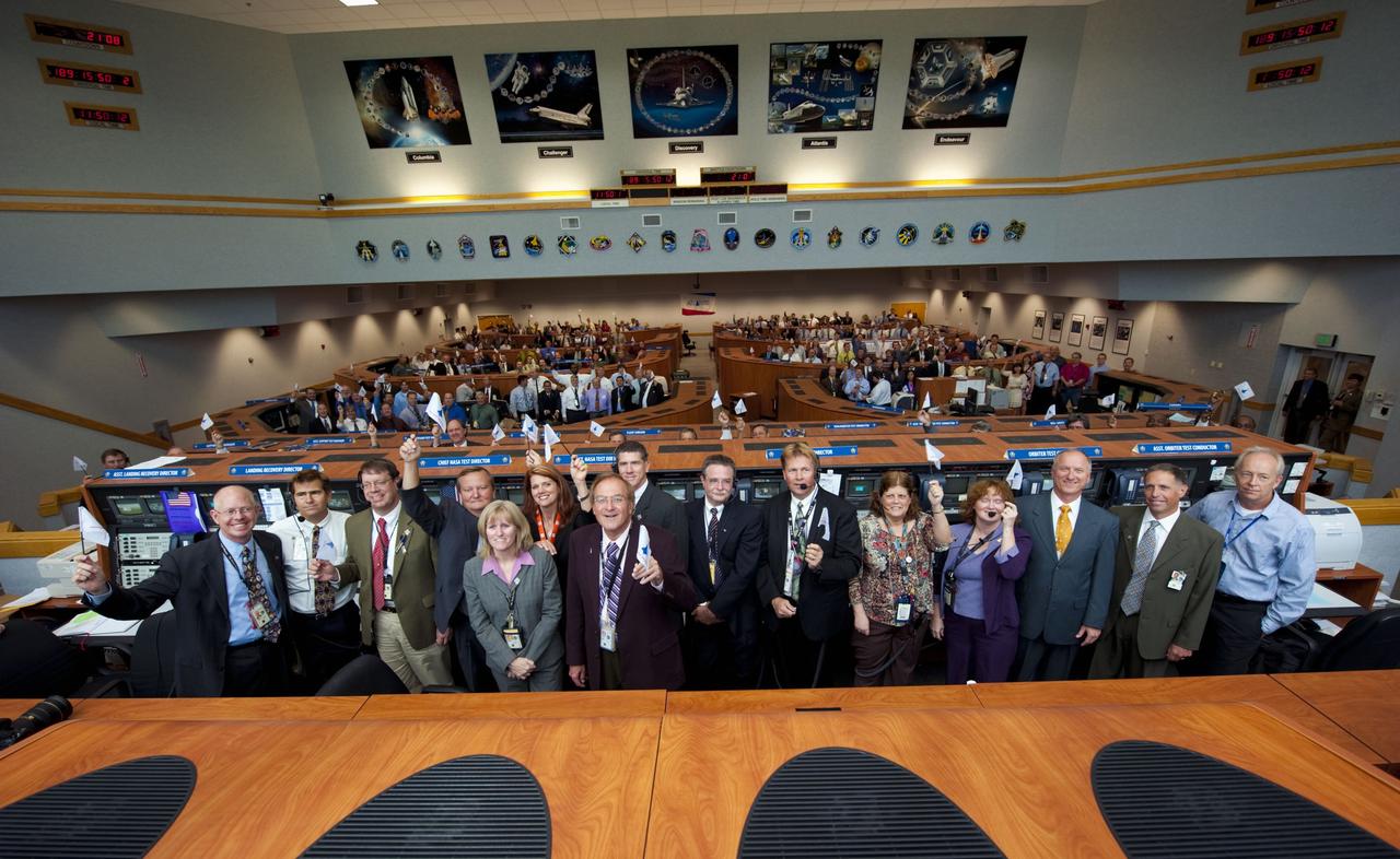 CAPE CANAVERAL, Fla. -- Launch controllers wave their STS-135 shuttle launch team member flags and cheer in Firing Room 4 of the Launch Control Center following the successful launch of space shuttle Atlantis from NASA's Kennedy Space Center in Florida. In the foreground, from left, are NASA Test Directors Steve Payne and Bob Holl; Landing and Recovery Director Greg Gaddis; Shuttle Launch Director Mike Leinbach; Atlantis' NASA Flow Director Angie Brewer; NASA Test Director Charlie Blackwell-Thompson; STS-135 Launch Commentator George Diller; NASA Test Directors Jeremy Graeber, Tim Potter, and Jeff Spaulding; Orbiter Test Conductor Roberta Wyrick; Assistant Orbiter Test Conductor Laurie Sally; Assistant Launch Director Pete Nickolenko; United Space Alliance Vice President of Launch and Recovery Systems Mark Nappi; and United Space Alliance Test Conductor Mark Paxton. Atlantis began its final flight, the STS-135 mission to the International Space Station, at 11:29 a.m. EDT on July 8. STS-135 will deliver the Raffaello multi-purpose logistics module packed with supplies and spare parts for the International Space Station. Atlantis also is flying the Robotic Refueling Mission experiment that will investigate the potential for robotically refueling existing satellites in orbit. In addition, Atlantis will return with a failed ammonia pump module to help NASA better understand the failure mechanism and improve pump designs for future systems. STS-135 is the 33rd flight of Atlantis, the 37th shuttle mission to the space station, and the 135th and final mission of NASA's Space Shuttle Program. For more information, visit www.nasa.gov/mission_pages/shuttle/shuttlemissions/sts135/index.html. Photo credit: NASA/Kim Shiflett