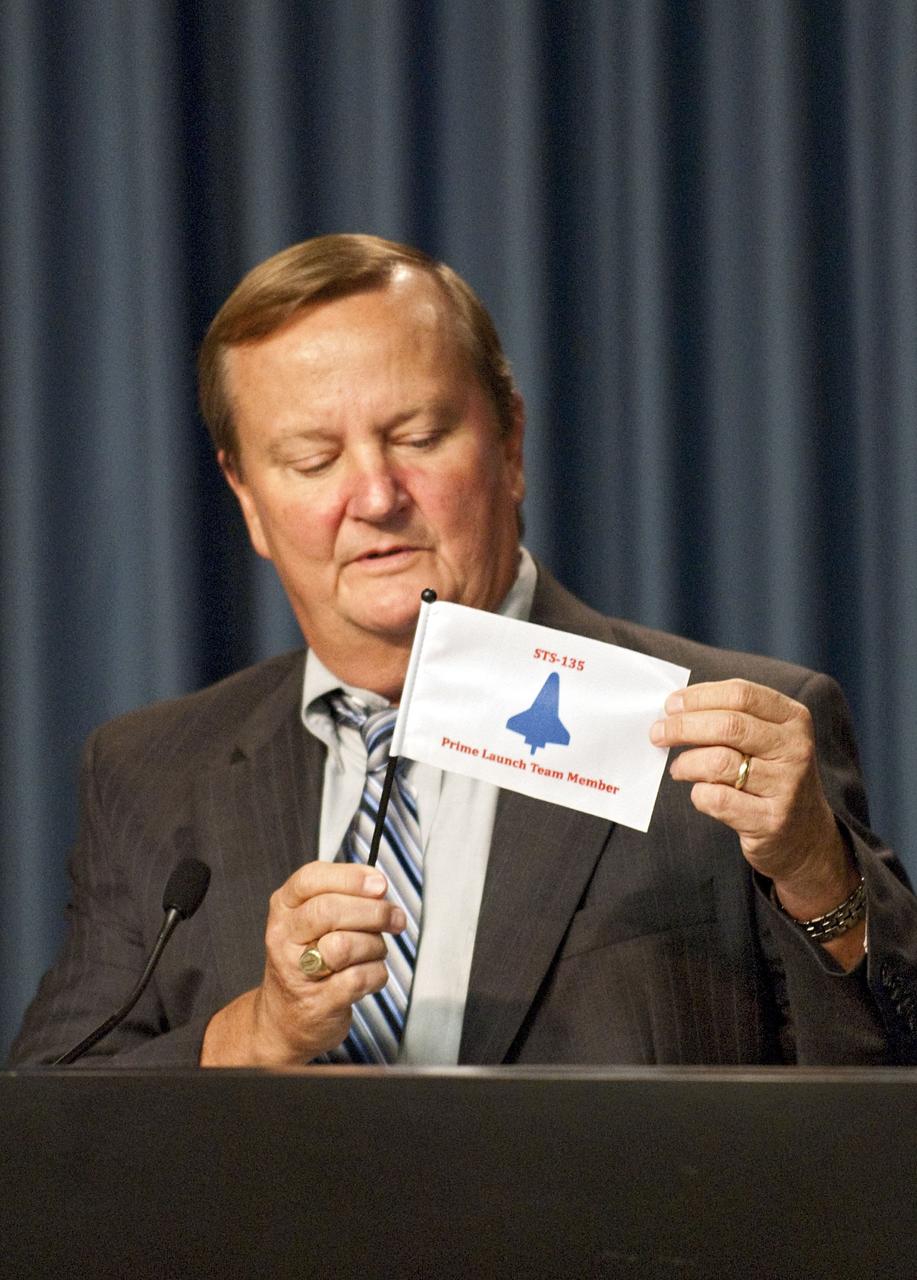 CAPE CANAVERAL, Fla. -- After a briefing in the Press Site auditorium at NASA's Kennedy Space Center in Florida, Shuttle Launch Director Mike Leinbach waves his STS-135 shuttle launch team member flag after the successful launch of space shuttle Atlantis. Atlantis began its final flight at 11:29 a.m. EDT on July 8. STS-135 will deliver the Raffaello multi-purpose logistics module packed with supplies and spare parts for the International Space Station. Atlantis also will fly the Robotic Refueling Mission experiment that will investigate the potential for robotically refueling existing satellites in orbit. In addition, Atlantis will return with a failed ammonia pump module to help NASA better understand the failure mechanism and improve pump designs for future systems. STS-135 will be the 33rd flight of Atlantis, the 37th shuttle mission to the space station, and the 135th and final mission of NASA's Space Shuttle Program. For more information, visit www.nasa.gov/mission_pages/shuttle/shuttlemissions/sts135/index.html. Photo credit: NASA/Kim Shiflett