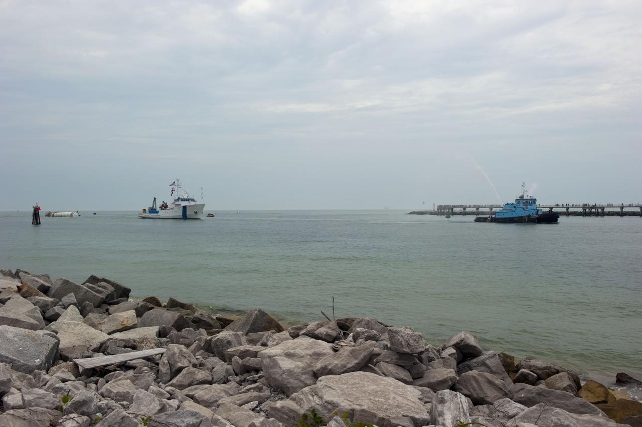 CAPE CANAVERAL, Fla. -- Liberty Star, one of NASA's solid rocket booster retrieval ships, tows a spent booster from space shuttle Atlantis' final launch, to Port Canaveral in Florida. A Cape Canaveral Port Authority tug sends a spray of water through its cannon as a welcome back to the Port. The shuttle's two solid rocket booster casings and associated flight hardware are recovered in the Atlantic Ocean after every launch by Freedom Star and Liberty Star. The boosters impact the Atlantic about seven minutes after liftoff and the retrieval ships are stationed about 10 miles from the impact area at the time of splashdown. After the spent segments are processed, they will be transported to Utah, where they will be deserviced and stored, if needed.        Atlantis began its final flight at 11:29 a.m. EDT on July 8 to deliver the Raffaello multi-purpose logistics module packed with supplies and spare parts for the International Space Station. Atlantis also delivers the Robotic Refueling Mission experiment that will investigate the potential for robotically refueling existing satellites in orbit to the station. In addition, Atlantis will return with a failed ammonia pump module to help NASA better understand the failure mechanism and improve pump designs for future systems. STS-135 is the 33rd flight of Atlantis, the 37th shuttle mission to the space station, and the 135th and final mission of NASA's Space Shuttle Program. For more information, visit www.nasa.gov/mission_pages/shuttle/shuttlemissions/sts135/index.html. Photo credit: NASA/Kim Shiflett