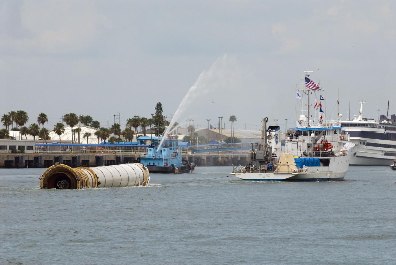 CAPE CANAVERAL, Fla. -- Liberty Star, one of NASA's solid rocket booster retrieval ships, tows a spent booster from space shuttle Atlantis' final launch, to Port Canaveral in Florida. A Cape Canaveral Port Authority tug sends a spray of water through its cannon as a welcome back to the Port. The shuttle's two solid rocket booster casings and associated flight hardware are recovered in the Atlantic Ocean after every launch by Freedom Star and Liberty Star. The boosters impact the Atlantic about seven minutes after liftoff and the retrieval ships are stationed about 10 miles from the impact area at the time of splashdown. After the spent segments are processed, they will be transported to Utah, where they will be deserviced and stored, if needed. Atlantis began its final flight at 11:29 a.m. EDT on July 8 to deliver the Raffaello multi-purpose logistics module packed with supplies and spare parts for the International Space Station. Atlantis also delivers the Robotic Refueling Mission experiment that will investigate the potential for robotically refueling existing satellites in orbit to the station. In addition, Atlantis will return with a failed ammonia pump module to help NASA better understand the failure mechanism and improve pump designs for future systems. STS-135 is the 33rd flight of Atlantis, the 37th shuttle mission to the space station, and the 135th and final mission of NASA's Space Shuttle Program. For more information, visit www.nasa.gov/mission_pages/shuttle/shuttlemissions/sts135/index.html. Photo credit: NASA/Kim Shiflett
