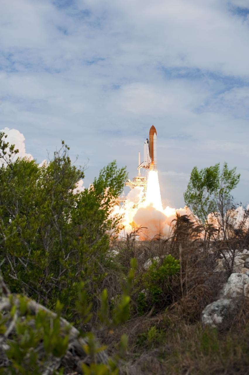 CAPE CANAVERAL, Fla. -- At NASA's Kennedy Space Center in Florida, space shuttle Atlantis lifts off of Launch Pad 39A leaving behind a billow of steam and smoke as it heads upwards past the tower on its STS-135 mission to the International Space Station.      Atlantis with its crew of four; Commander Chris Ferguson, Pilot Doug Hurley, Mission Specialists Sandy Magnus and Rex Walheim, lifted off at 11:29 a.m. EDT on July 8, 2011 to deliver the Raffaello multi-purpose logistics module packed with supplies and spare parts for the International Space Station. Atlantis also will fly the Robotic Refueling Mission experiment that will investigate the potential for robotically refueling existing satellites in orbit. In addition, Atlantis will return with a failed ammonia pump module to help NASA better understand the failure mechanism and improve pump designs for future systems. STS-135 is the 33rd flight of Atlantis, the 37th shuttle mission to the space station, and the 135th and final mission of NASA's Space Shuttle Program. For more information, visit www.nasa.gov/mission_pages/shuttle/shuttlemissions/sts135/index.html. Photo credit: NASA/Sandra Joseph and Kevin O'Connell