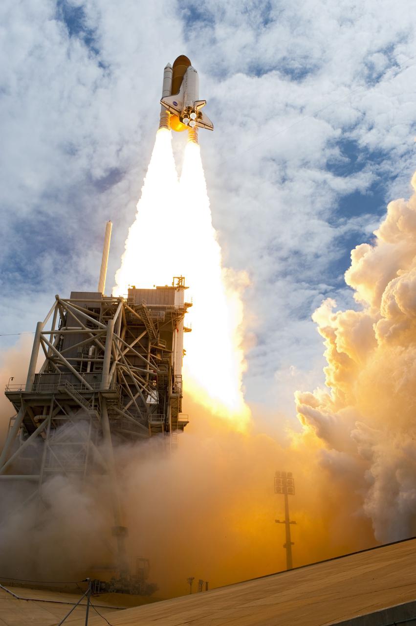 CAPE CANAVERAL, Fla. -- At NASA's Kennedy Space Center in Florida, space shuttle Atlantis' main engines and solid rocket boosters ignite on Launch Pad 39A leaving behind a billow of steam and smoke as it lifts off past the tower into the clouds on its STS-135 mission to the International Space Station.            Atlantis with its crew of four; Commander Chris Ferguson, Pilot Doug Hurley, Mission Specialists Sandy Magnus and Rex Walheim, lifted off at 11:29 a.m. EDT on July 8, 2011 to deliver the Raffaello multi-purpose logistics module packed with supplies and spare parts for the International Space Station. Atlantis also will fly the Robotic Refueling Mission experiment that will investigate the potential for robotically refueling existing satellites in orbit. In addition, Atlantis will return with a failed ammonia pump module to help NASA better understand the failure mechanism and improve pump designs for future systems. STS-135 is the 33rd flight of Atlantis, the 37th shuttle mission to the space station, and the 135th and final mission of NASA's Space Shuttle Program. For more information, visit www.nasa.gov/mission_pages/shuttle/shuttlemissions/sts135/index.html. Photo credit: NASA/Sandra Joseph and Kevin O'Connell