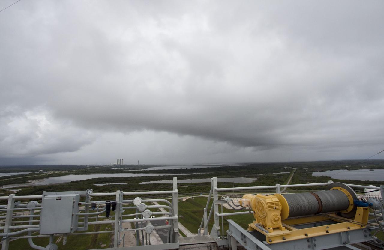 CAPE CANAVERAL, Fla.-- The Vehicle Assembly Building at NASA's Kennedy Space Center in Florida stands on the horizon as rain clouds move over the space center soon after space shuttle Atlantis is revealed on Launch Pad 39A following the move of the rotating service structure (RSS). The structure provides weather protection and access to the shuttle while it awaits liftoff on the pad. RSS "rollback" marks a major milestone in Atlantis' STS-135 mission countdown. Atlantis and its crew of four; Commander Chris Ferguson, Pilot Doug Hurley and Mission Specialists Sandy Magnus and Rex Walheim, are scheduled to lift off at 11:26 a.m. EDT on July 8 to deliver the Raffaello multi-purpose logistics module packed with supplies and spare parts to the International Space Station. Atlantis also will fly the Robotic Refueling Mission experiment that will investigate the potential for robotically refueling existing satellites in orbit. In addition, Atlantis will return with a failed ammonia pump module to help NASA better understand the failure mechanism and improve pump designs for future systems. STS-135 will be the 33rd flight of Atlantis, the 37th shuttle mission to the space station, and the 135th and final mission of NASA's Space Shuttle Program. For more information visit, www.nasa.gov/mission_pages/shuttle/shuttlemissions/sts135/index.html. Photo credit: NASA/Ken Thornsley