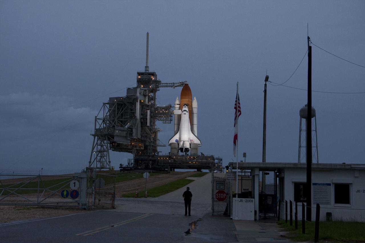 CAPE CANAVERAL, Fla. -- Space shuttle Atlantis is revealed on Launch Pad 39A at NASA's Kennedy Space Center in Florida bathed in xenon lights following the move of the rotating service structure (RSS). The structure provides weather protection and access to the shuttle while it awaits liftoff on the pad. RSS retract marks a major milestone in Atlantis' STS-135 mission countdown. A NASA security guard takes a moment to look at Atlantis on its seaside launch pad before its final flight.      Atlantis and its crew of four; Commander Chris Ferguson, Pilot Doug Hurley, Mission Specialists Sandy Magnus and Rex Walheim are scheduled to lift off at 11:26 a.m. EDT on July 8 to deliver the Raffaello multi-purpose logistics module packed with supplies and spare parts for the International Space Station. Atlantis also will fly the Robotic Refueling Mission experiment that will investigate the potential for robotically refueling existing satellites in orbit. In addition, Atlantis will return with a failed ammonia pump module to help NASA better understand the failure mechanism and improve pump designs for future systems. STS-135 is the 33rd flight of Atlantis, the 37th shuttle mission to the space station, and the 135th and final mission of NASA's Space Shuttle Program. For more information, visit www.nasa.gov/mission_pages/shuttle/shuttlemissions/sts135/index.html. Photo credit: Ken Thornsley