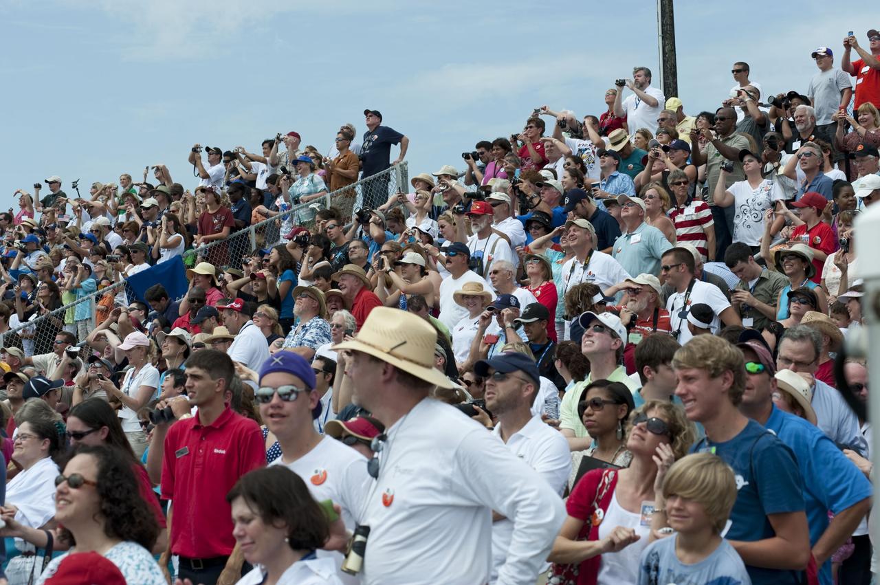 CAPE CANAVERAL, Fla. -- At the Banana River Creek VIP viewing area at NASA's Kennedy Space Center in Florida, spectators smile with delight as they watch space shuttle Atlantis soar into space on its STS-135 mission to the International Space Station. Atlantis with its crew of four; Commander Chris Ferguson, Pilot Doug Hurley, Mission Specialists Sandy Magnus and Rex Walheim, lifted off at 11:29 a.m. EDT on July 8, 2011 to deliver the Raffaello multi-purpose logistics module packed with supplies and spare parts for the International Space Station. Atlantis also will fly the Robotic Refueling Mission experiment that will investigate the potential for robotically refueling existing satellites in orbit. In addition, Atlantis will return with a failed ammonia pump module to help NASA better understand the failure mechanism and improve pump designs for future systems. STS-135 is the 33rd flight of Atlantis, the 37th shuttle mission to the space station, and the 135th and final mission of NASA's Space Shuttle Program. For more information, visit www.nasa.gov/mission_pages/shuttle/shuttlemissions/sts135/index.html. Photo credit: NASA/Chad Baumer