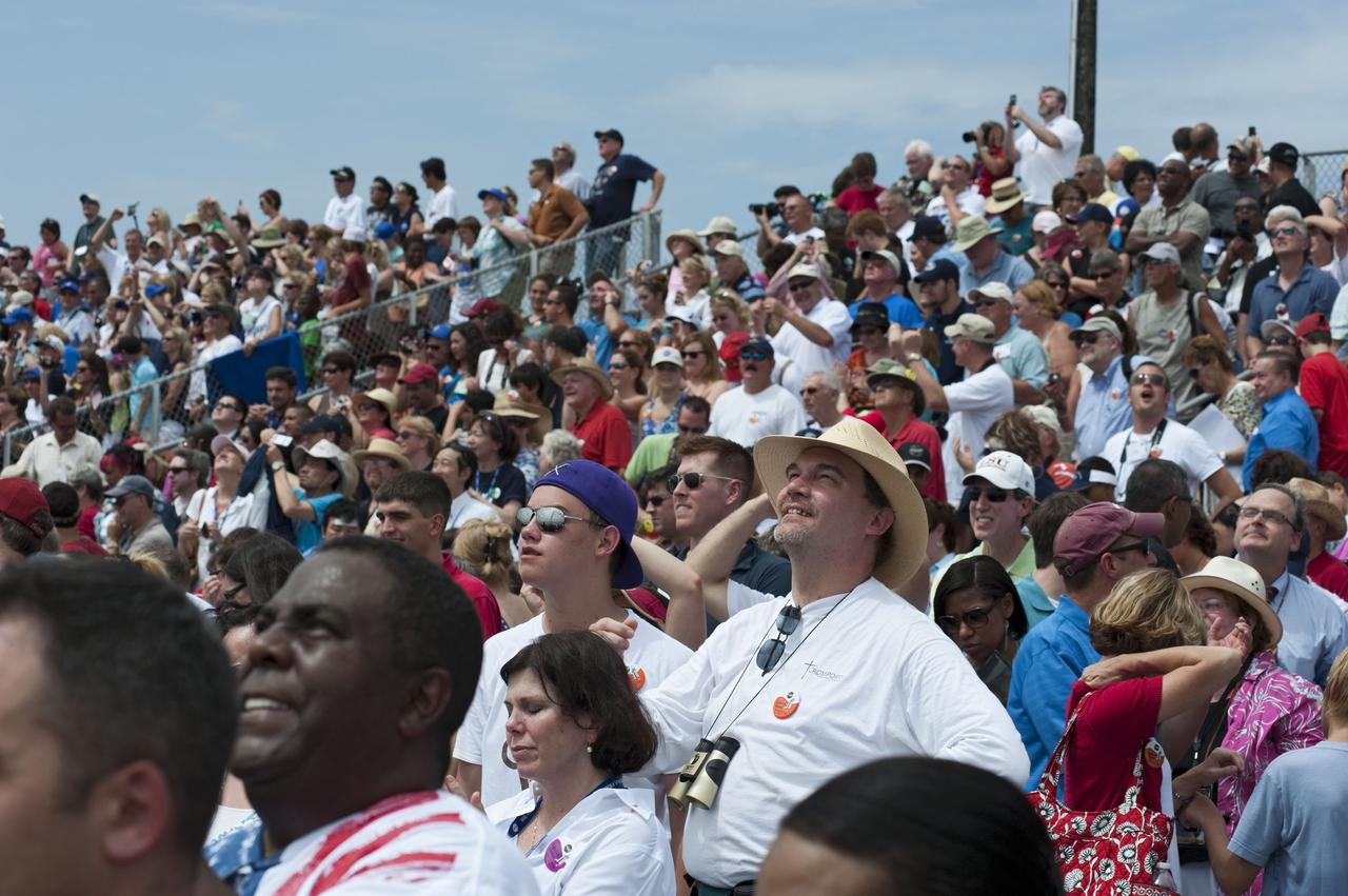 CAPE CANAVERAL, Fla. -- At the Banana River Creek VIP viewing area at NASA's Kennedy Space Center in Florida, spectators smile with delight as they watch space shuttle Atlantis soar into space on its STS-135 mission to the International Space Station.        Atlantis with its crew of four; Commander Chris Ferguson, Pilot Doug Hurley, Mission Specialists Sandy Magnus and Rex Walheim, lifted off at 11:29 a.m. EDT on July 8, 2011 to deliver the Raffaello multi-purpose logistics module packed with supplies and spare parts for the International Space Station. Atlantis also will fly the Robotic Refueling Mission experiment that will investigate the potential for robotically refueling existing satellites in orbit. In addition, Atlantis will return with a failed ammonia pump module to help NASA better understand the failure mechanism and improve pump designs for future systems. STS-135 is the 33rd flight of Atlantis, the 37th shuttle mission to the space station, and the 135th and final mission of NASA's Space Shuttle Program. For more information, visit www.nasa.gov/mission_pages/shuttle/shuttlemissions/sts135/index.html. Photo credit: NASA/Chad Baumer