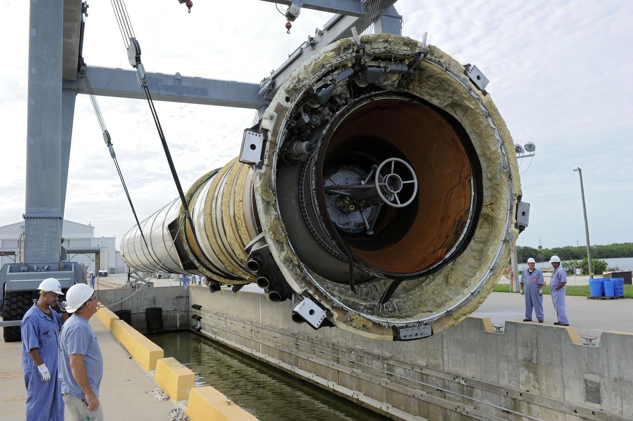 CAPE CANAVERAL, Fla. – Workers monitor the progress as one of two solid rocket boosters is lifted above a mooring at Port Canaveral in Florida.  Liberty Star, one of NASA’s two booster retrieval ships, towed the spent booster from space shuttle Atlantis’ final launch to the port. The shuttle’s two solid rocket booster casings and associated flight hardware are recovered in the Atlantic Ocean after every launch by Freedom Star and Liberty Star. The boosters impact the Atlantic about seven minutes after liftoff, and the retrieval ships are stationed about 10 miles from the impact area at the time of splashdown.    After the spent segments are processed, they will be transported to Utah, where they will be deserviced and stored, if needed. Atlantis began its final flight, STS-135, at 11:29 a.m. EDT on July 8 to deliver the Raffaello multi-purpose logistics module packed with supplies and spare parts to the International Space Station. Photo credit: NASA/Kim Shiflett