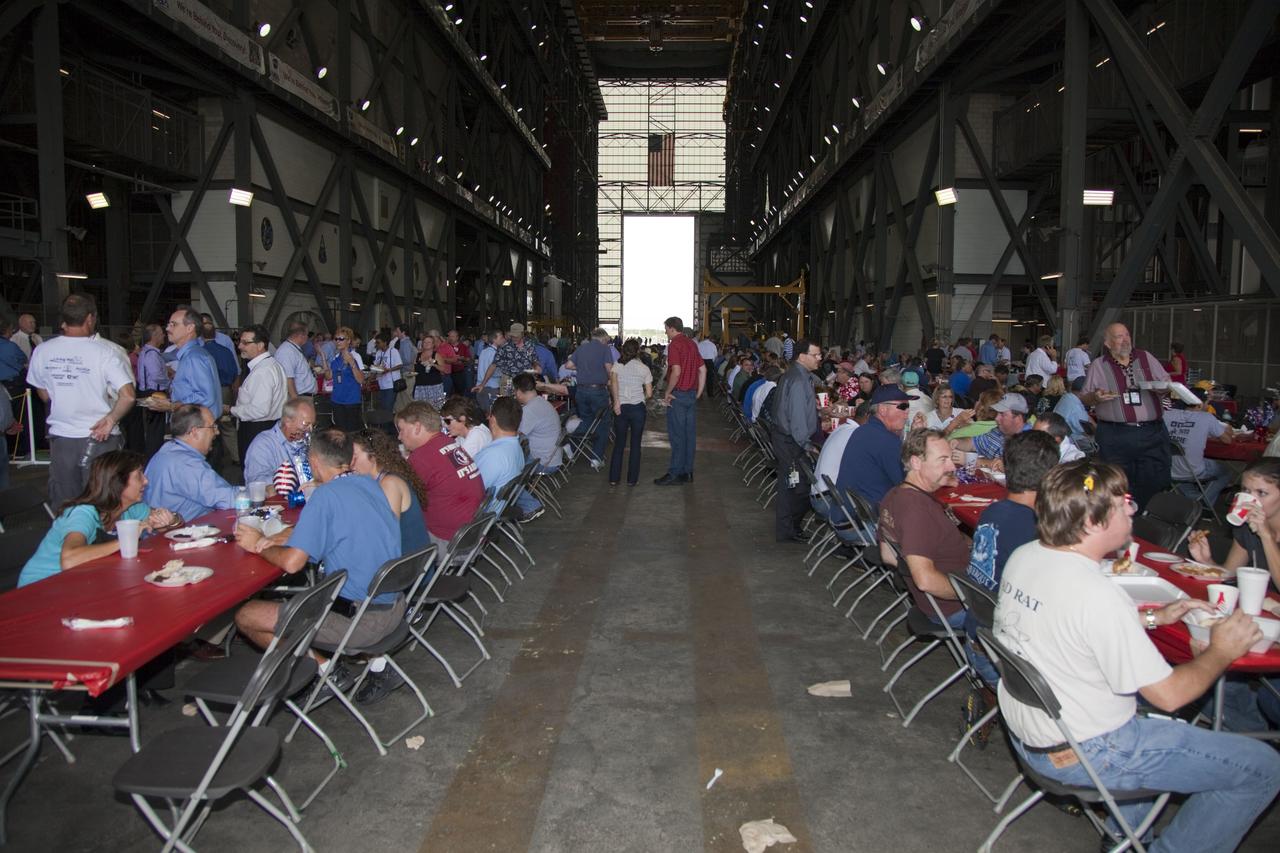CAPE CANAVERAL, Fla. -- Hundreds of space shuttle workers enjoy a meal at tables set up in the transfer aisle of NASA Kennedy Space Center's Vehicle Assembly Building. The occasion celebrated the successful launch of shuttle Atlantis on the STS-135 mission, the final flight of the agency's Space Shuttle Program. Atlantis, with its crew of Commander Chris Ferguson, Pilot Doug Hurley, Mission Specialists Sandy Magnus and Rex Walheim, lifted off at 11:29 a.m. EDT on July 8, 2011 to deliver the Raffaello multi-purpose logistics module packed with supplies and spare parts for the International Space Station. For more information, visit www.nasa.gov/mission_pages/shuttle/shuttlemissions/sts135/index.html. Photo credit: NASA/Frankie Martin