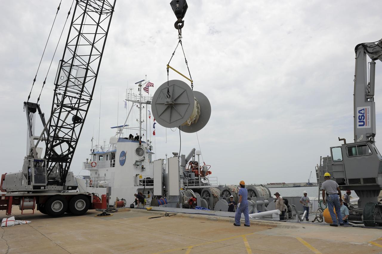 CAPE CANAVERAL, Fla. – A crane working from the dock at Hangar AF at Cape Canaveral Air Force Station in Florida removes one of the spools holding the parachutes and lines from the right spent boosters from space shuttle Atlantis' final launch. The parachutes and booster were gathered by the crews from the Liberty Star, one of NASA's solid rocket booster retrieval ships. The shuttle's two solid rocket booster casings and associated flight hardware are recovered in the Atlantic Ocean after every launch by Freedom Star and Liberty Star. The boosters impact the Atlantic about seven minutes after liftoff and the retrieval ships are stationed about 10 miles from the impact area at the time of splashdown. After the spent segments are processed, they will be transported to Utah, where they will be deserviced and stored, if needed. Atlantis began its final flight at 11:29 a.m. EDT on July 8 to deliver the Raffaello multi-purpose logistics module packed with supplies and spare parts for the International Space Station. Atlantis also delivers the Robotic Refueling Mission experiment that will investigate the potential for robotically refueling existing satellites in orbit to the station. In addition, Atlantis will return with a failed ammonia pump module to help NASA better understand the failure mechanism and improve pump designs for future systems. STS-135 is the 33rd flight of Atlantis, the 37th shuttle mission to the space station, and the 135th and final mission of NASA's Space Shuttle Program. For more information, visit www.nasa.gov/mission_pages/shuttle/shuttlemissions/sts135/index.html. Photo credit: NASA/Kim Shiflett