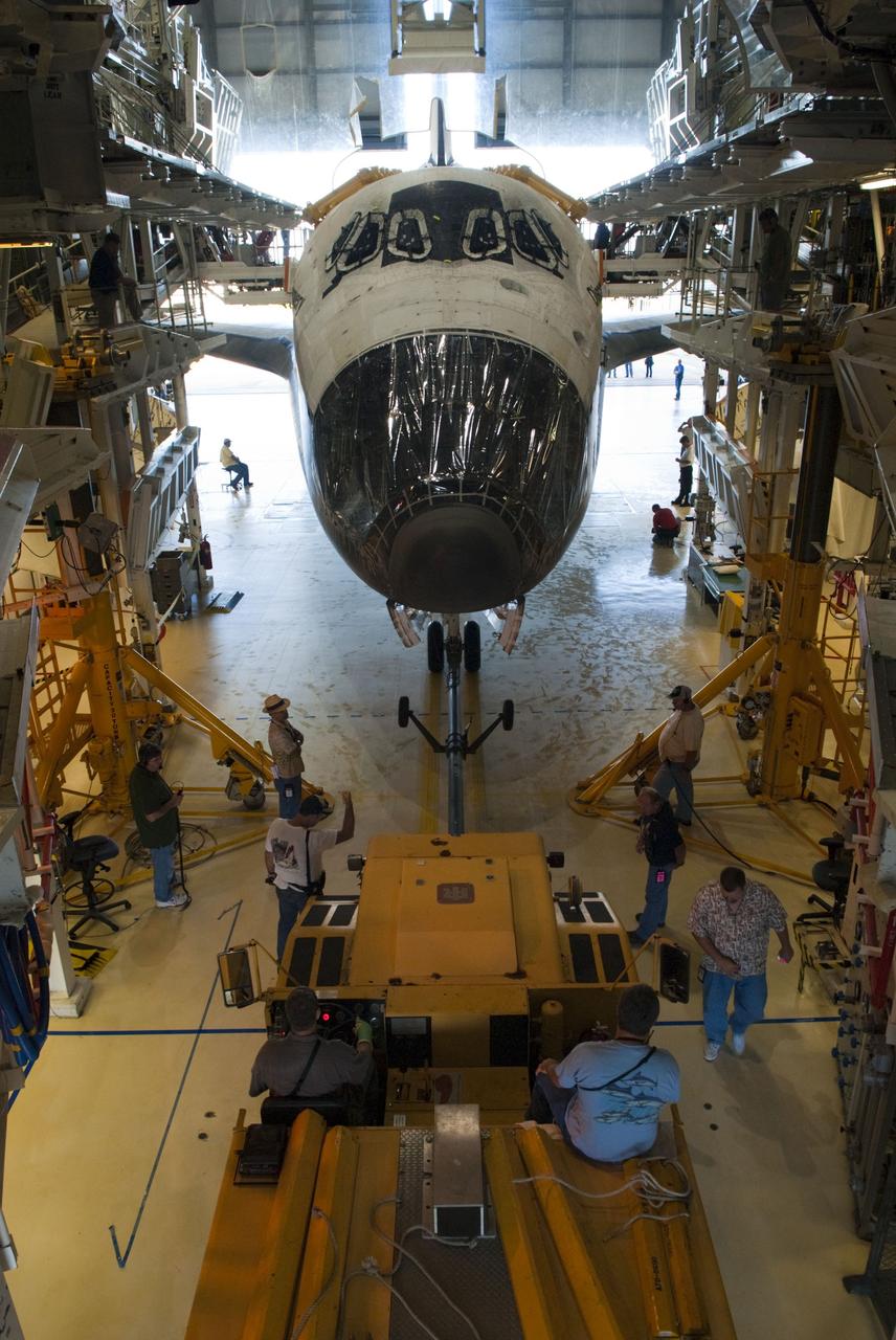 CAPE CANAVERAL, Fla. -- In Orbiter Processing Facility-2, or OPF-2, at NASA's Kennedy Space Center in Florida, workers prepare to tow space shuttle Discovery to the Vehicle Assembly Building, or VAB. Protective plastic covers the nose of Discovery where its forward reaction control system (FRCS) once resided. Discovery's FRCS was removed and shipped to White Sands Space Harbor in New Mexico for a full cleaning and deservicing before it is returned to Kennedy and reinstalled. Discovery will be stored inside the VAB for approximately one month while shuttle Atlantis undergoes processing in OPF-2 following its final mission, STS-135. Discovery flew its 39th and final mission, STS-133, in February and March 2011, and currently is being prepared for public display at the Smithsonian's National Air and Space Museum Steven F. Udvar-Hazy Center in Virginia. For more information about Discovery's Transition and Retirement, visit www.nasa.gov/mission_pages/shuttle/launch/discovery_rss_collection_archive_1.html. Photo credit: NASA/Jim Grossmann